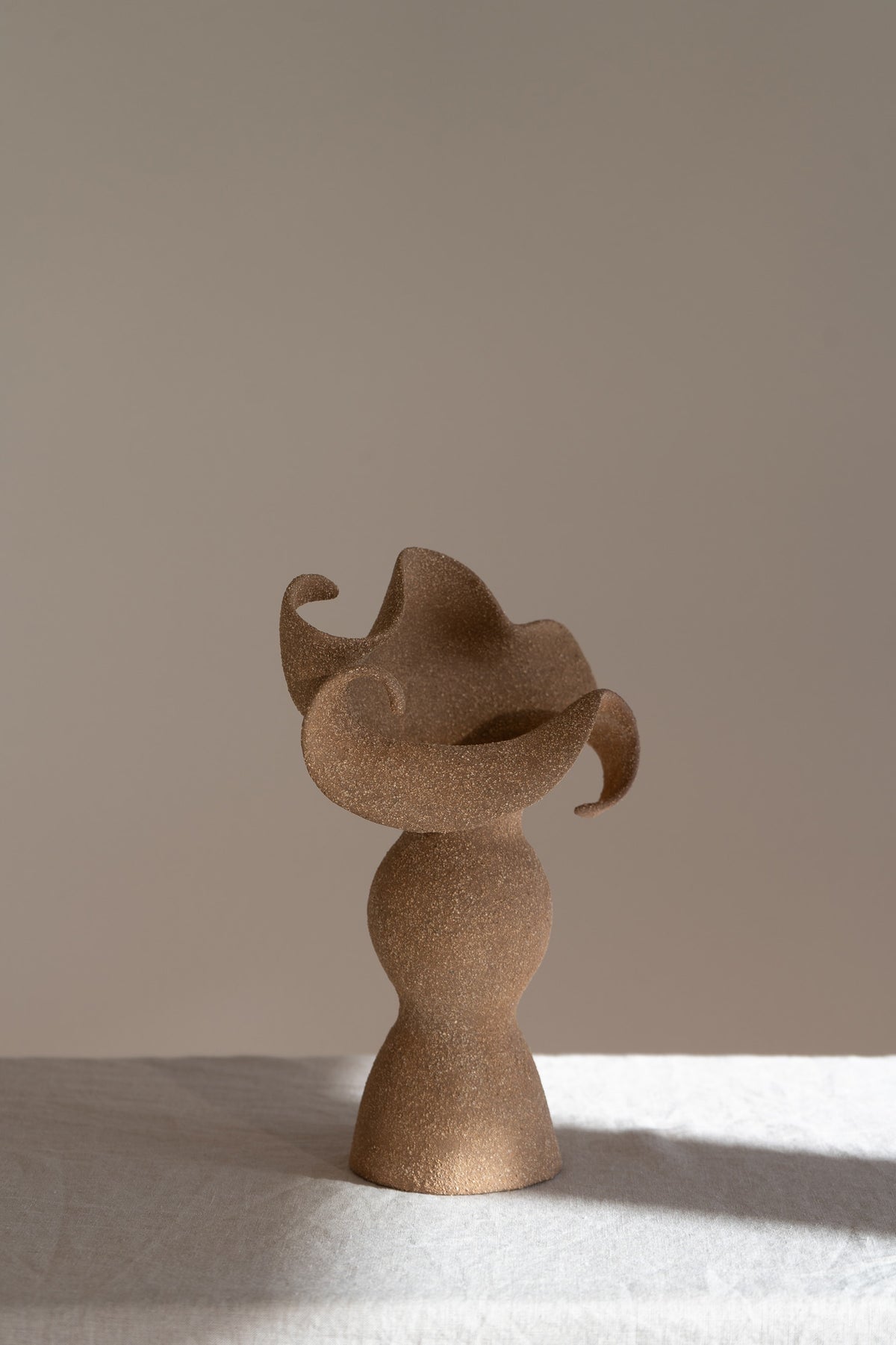 A beautifully crafted stoneware vase with curvaceous, organic outlines and soft brutalist forms. 