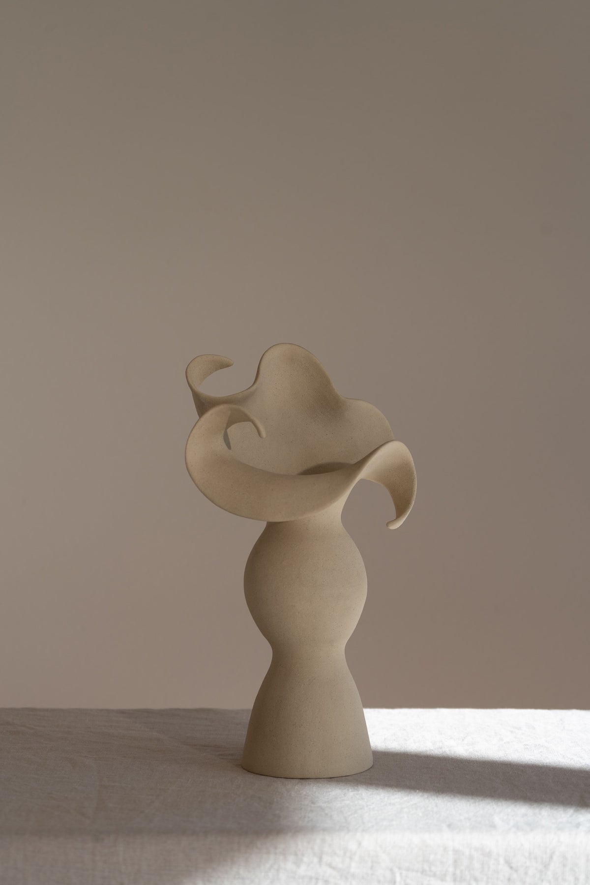 A beautiful stoneware vase, the Amorous Sculptural Vessel is a home decor art piece that mixes soft brutalism with natural grooves and curves.