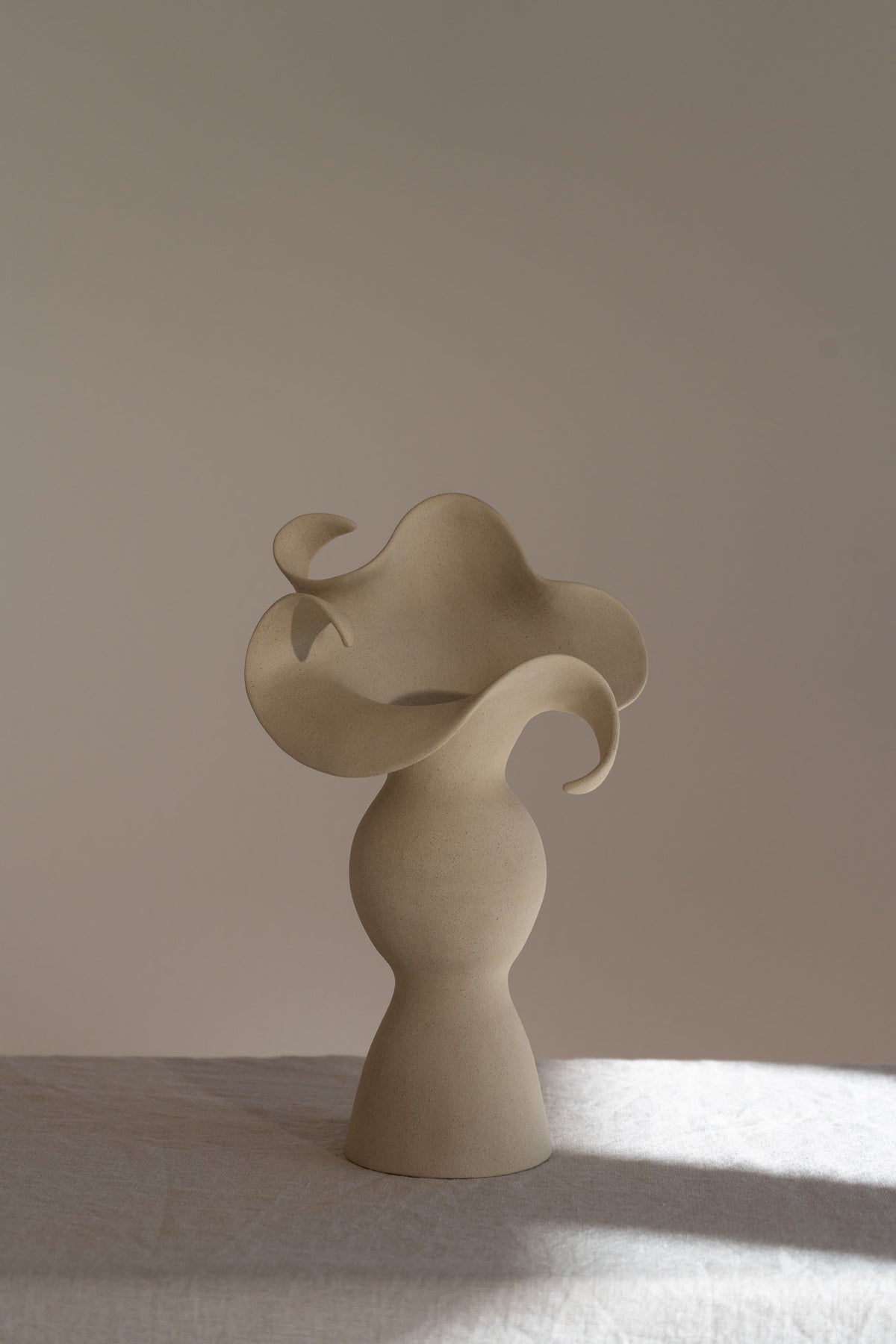 A beautiful stoneware vase, the Amorous Sculptural Vessel is a home decor art piece that mixes soft brutalism with natural grooves and curves.