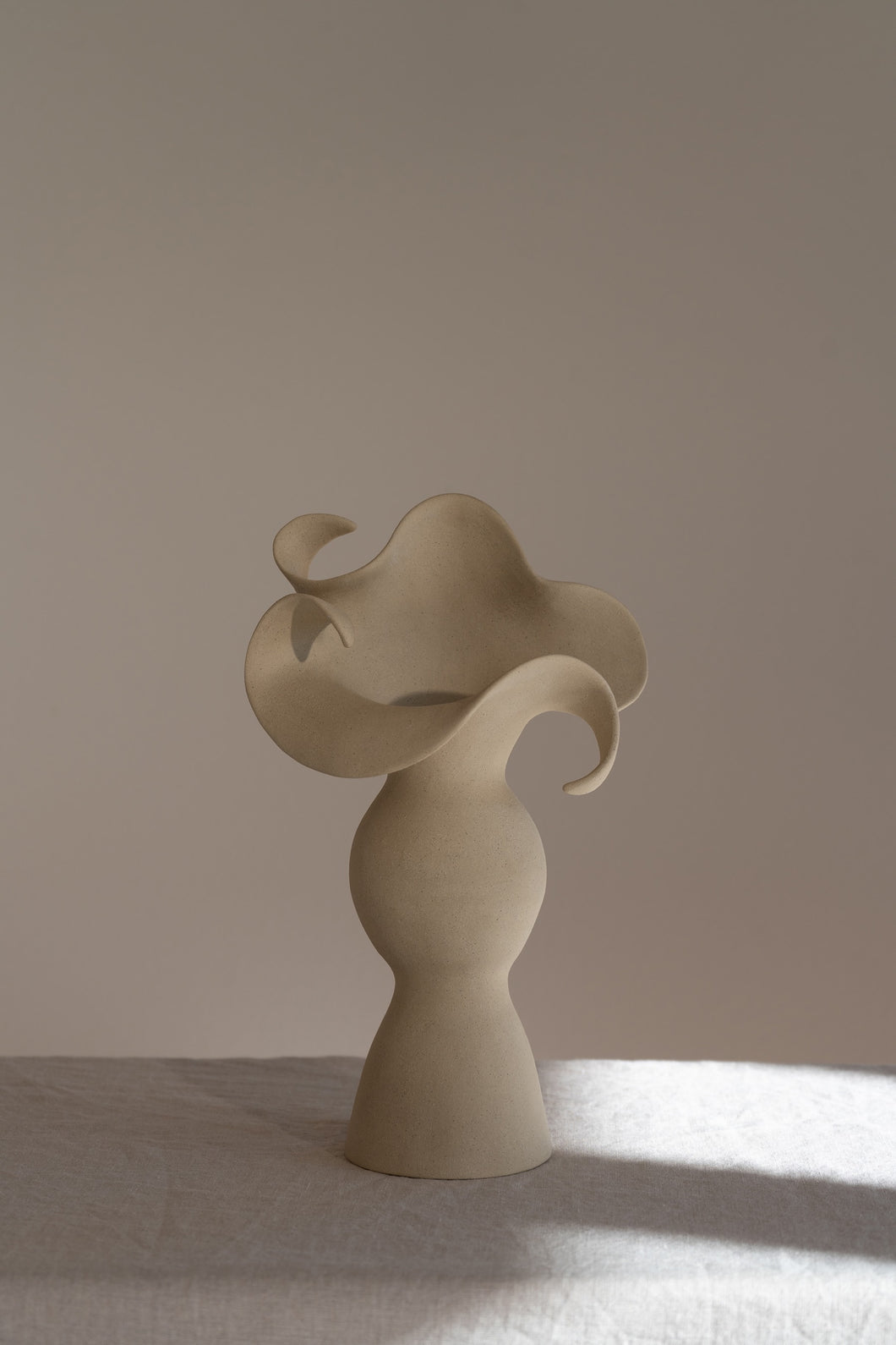 A beautiful stoneware vase, the Amorous Sculptural Vessel is a home decor art piece that mixes soft brutalism with natural grooves and curves.