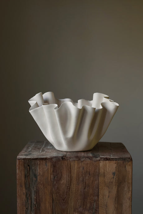 Handmade and featuring delicate, voluminous ruffles in textured clay. 