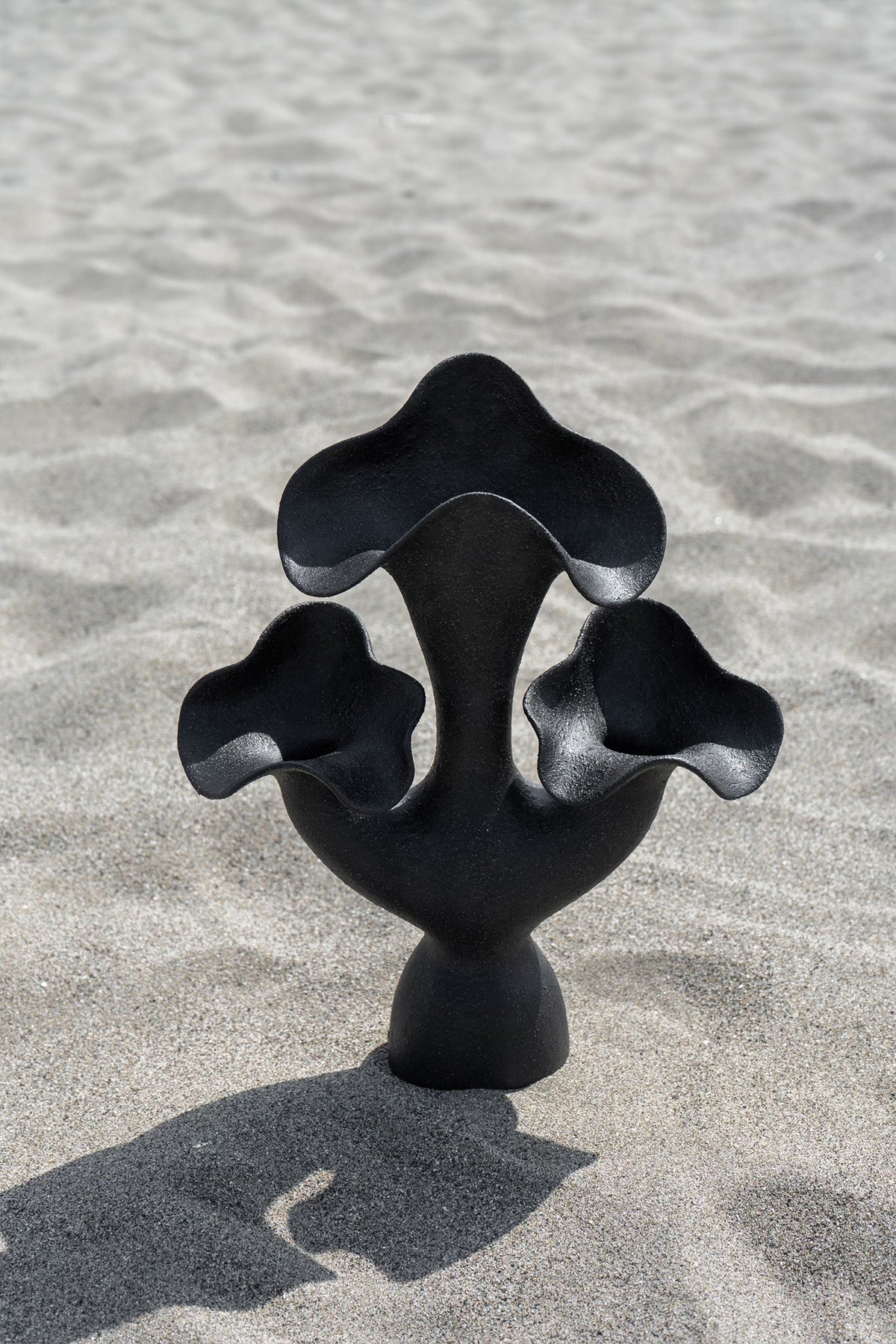 The Lilies Sculptural Vessel features a beautiful silhouette similar to its namesake flower, with soft petal-like curves blossoming from the vase openings.