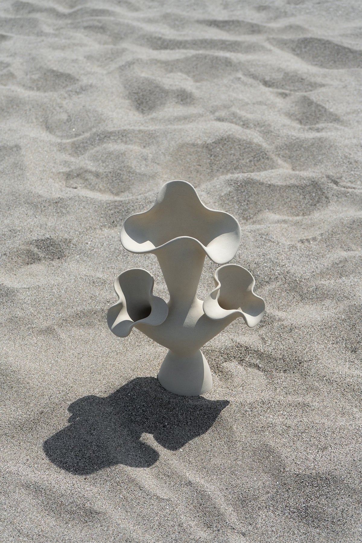 The Lilies Sculptural Vessel features a beautiful silhouette similar to its namesake flower, with soft petal-like curves blossoming from the vase openings.