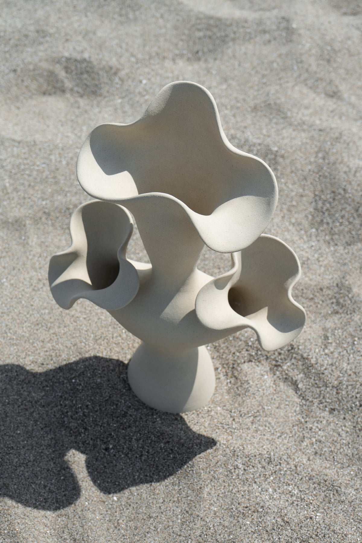The Lilies Sculptural Vessel features a beautiful silhouette similar to its namesake flower, with soft petal-like curves blossoming from the vase openings.