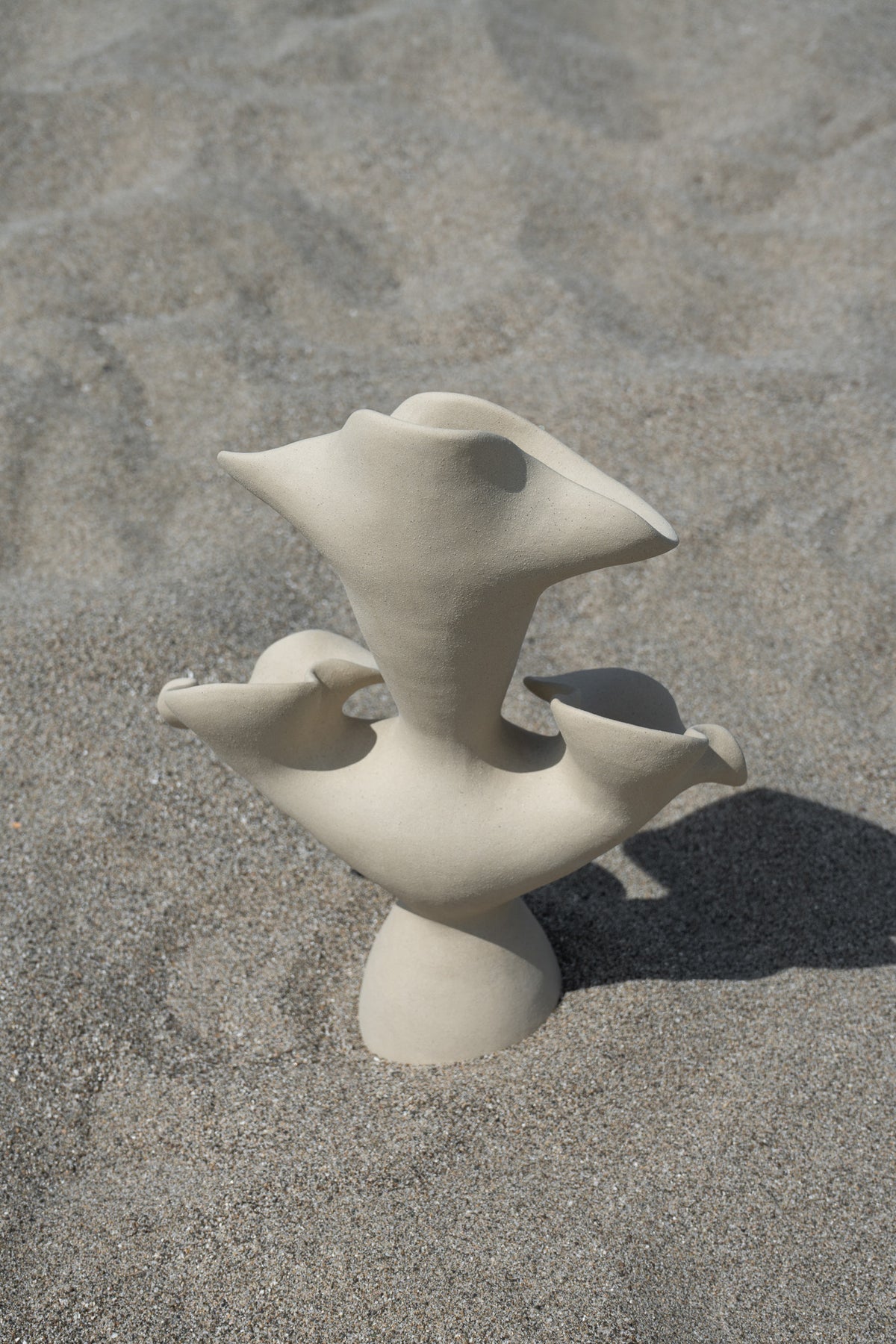 The Lilies Sculptural Vessel features a beautiful silhouette similar to its namesake flower, with soft petal-like curves blossoming from the vase openings.