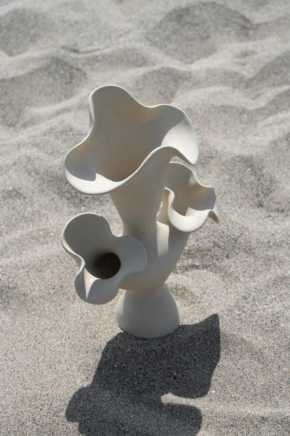 The Lilies Sculptural Vessel features a beautiful silhouette similar to its namesake flower, with soft petal-like curves blossoming from the vase openings.