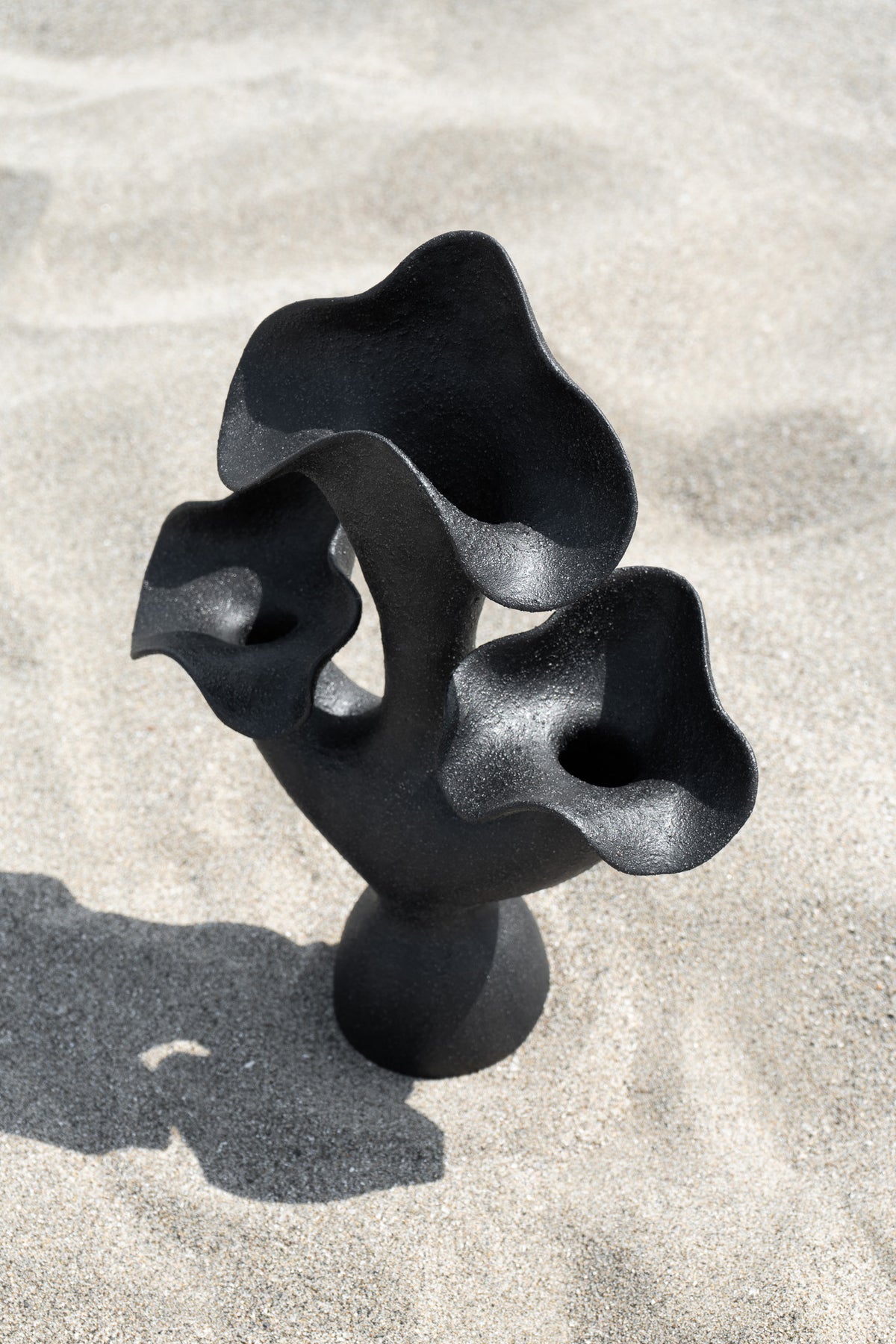 The Lilies Sculptural Vessel features a beautiful silhouette similar to its namesake flower, with soft petal-like curves blossoming from the vase openings.
