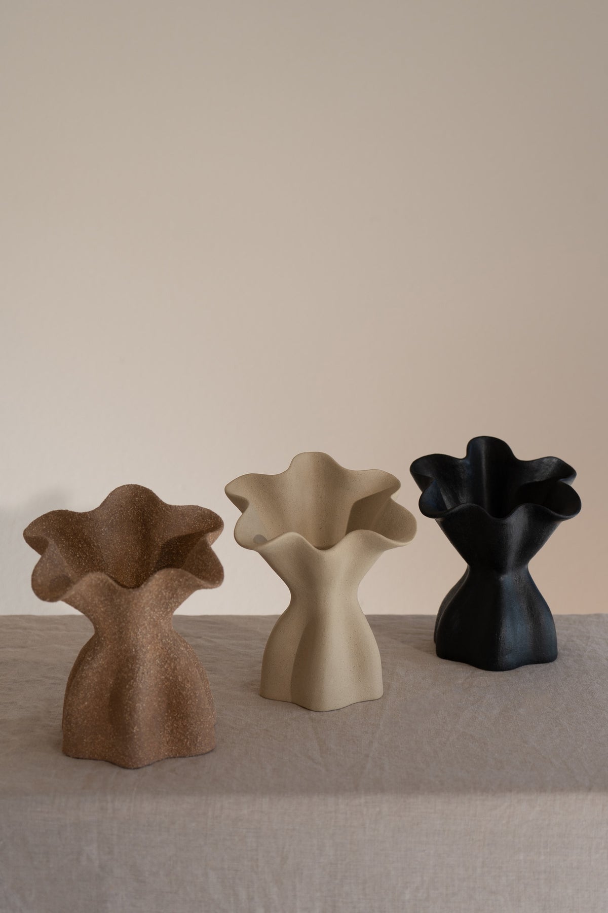 A beautifully crafted matte ceramic vase with soft, organic shapes and a glazed interior. 