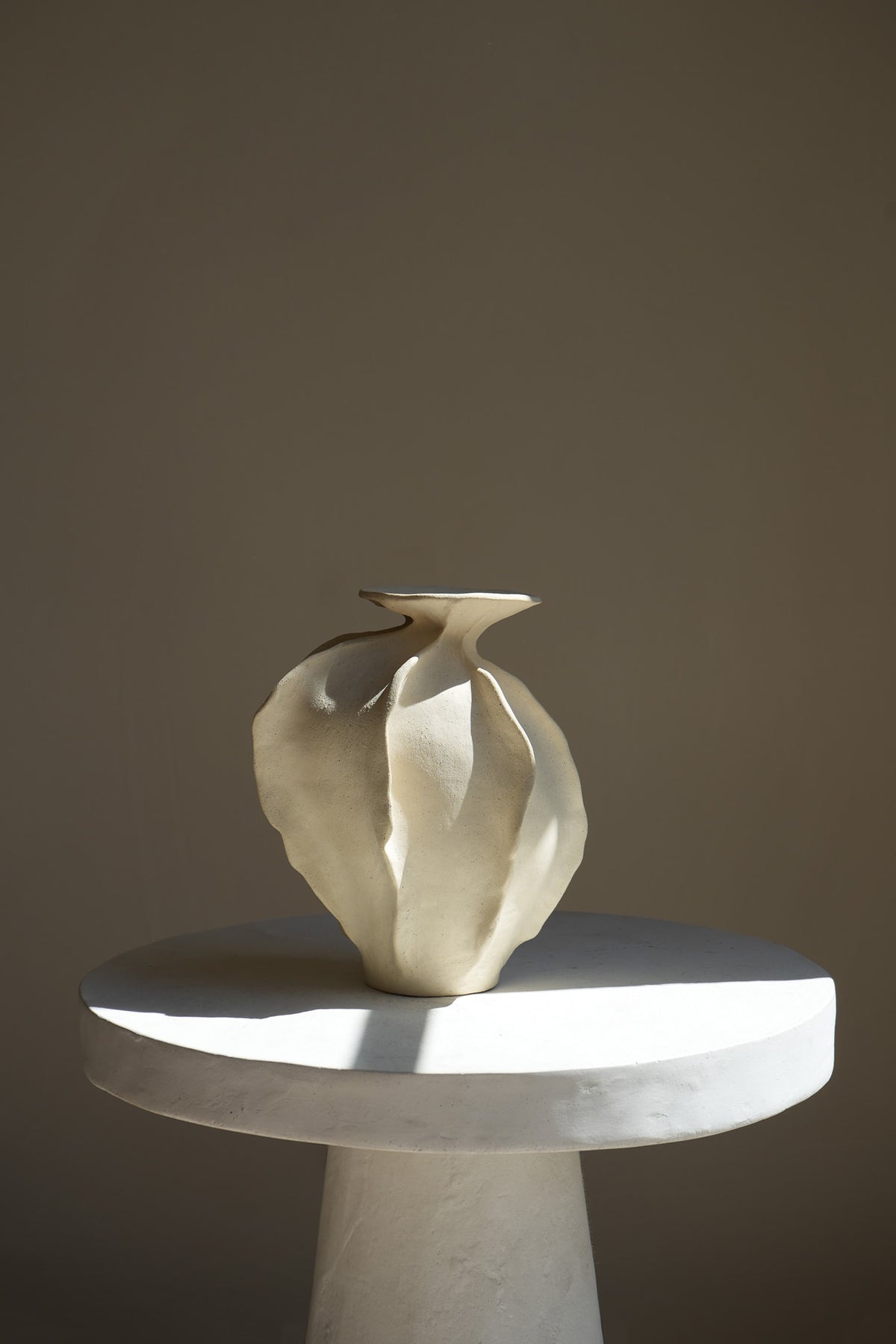 A sculptural ceramic piece inspired by nature's hills and seas. This dynamic, intricately designed vase features smooth curves and textured surfaces, capturing movement and elegance.