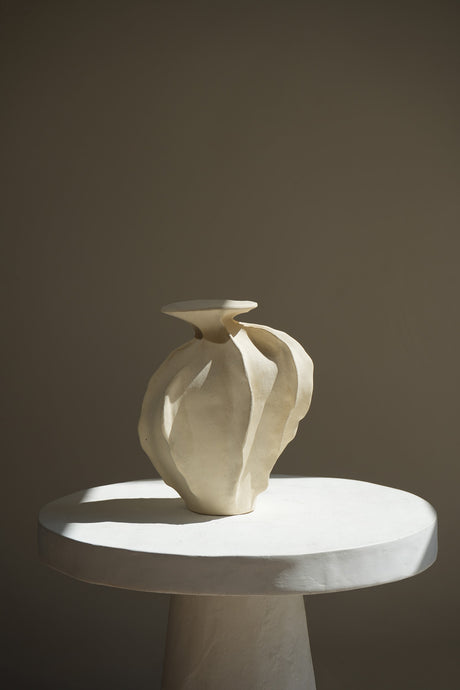 A sculptural ceramic piece inspired by nature's hills and seas. This dynamic, intricately designed vase features smooth curves and textured surfaces, capturing movement and elegance.