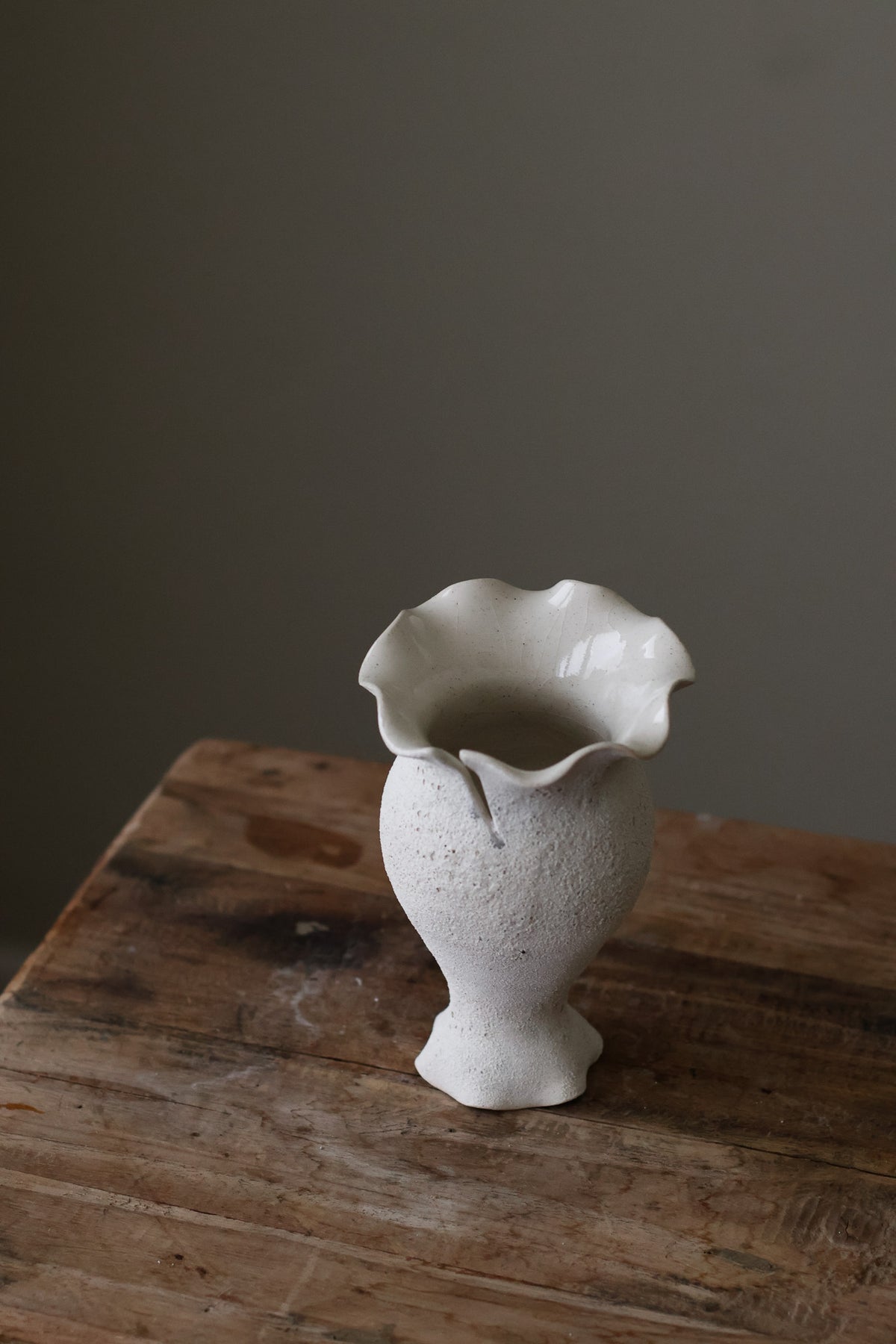 Blossoming Bud Vase in White Lava Glaze, Inspired by the tender rise of twin tulips from a single stem, this hand-built vase features two ruffled openings atop a shared base, each echoing the graceful unfurl of a bloom. 