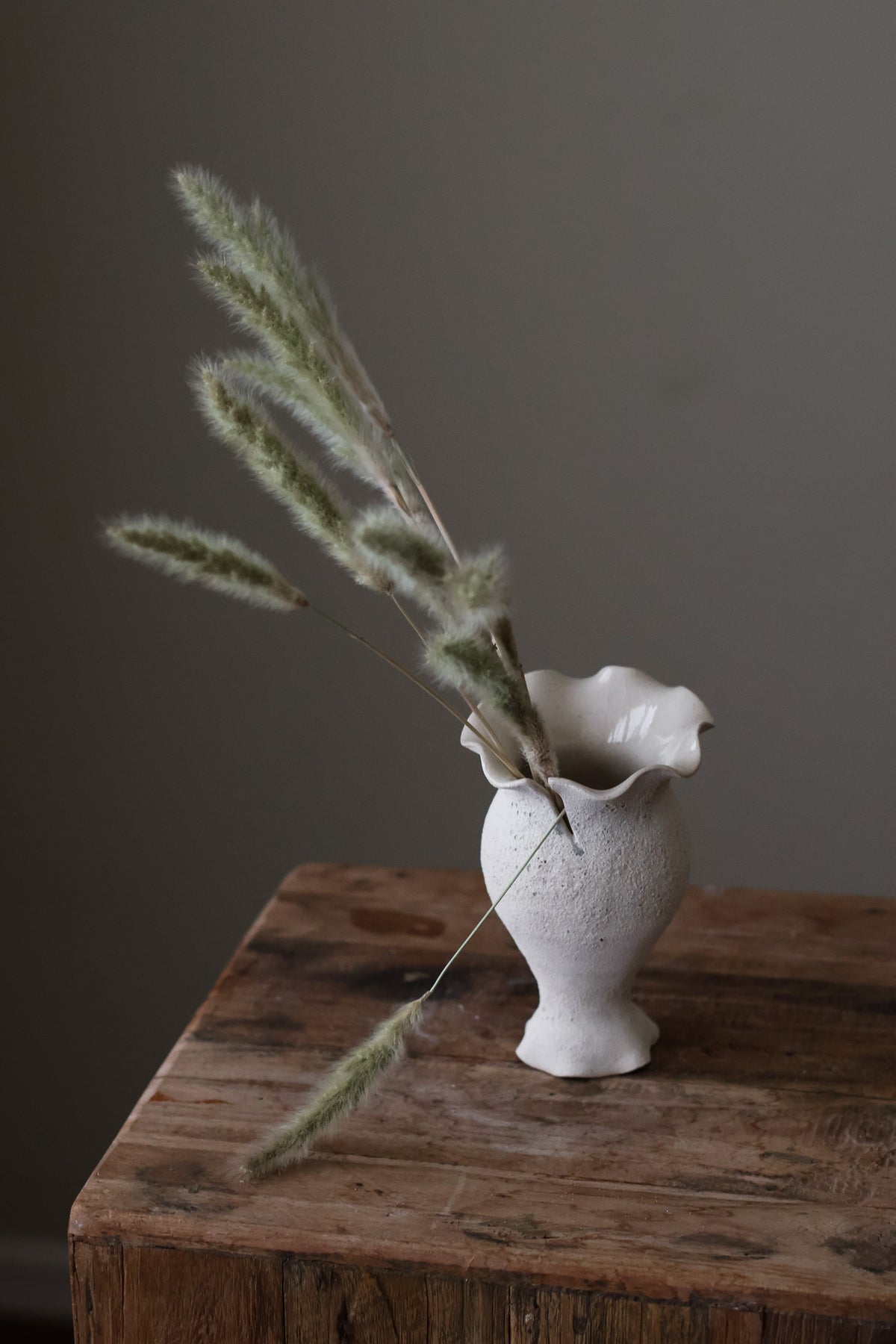 Blossoming Bud Vase in White Lava Glaze, Inspired by the tender rise of twin tulips from a single stem, this hand-built vase features two ruffled openings atop a shared base, each echoing the graceful unfurl of a bloom. 