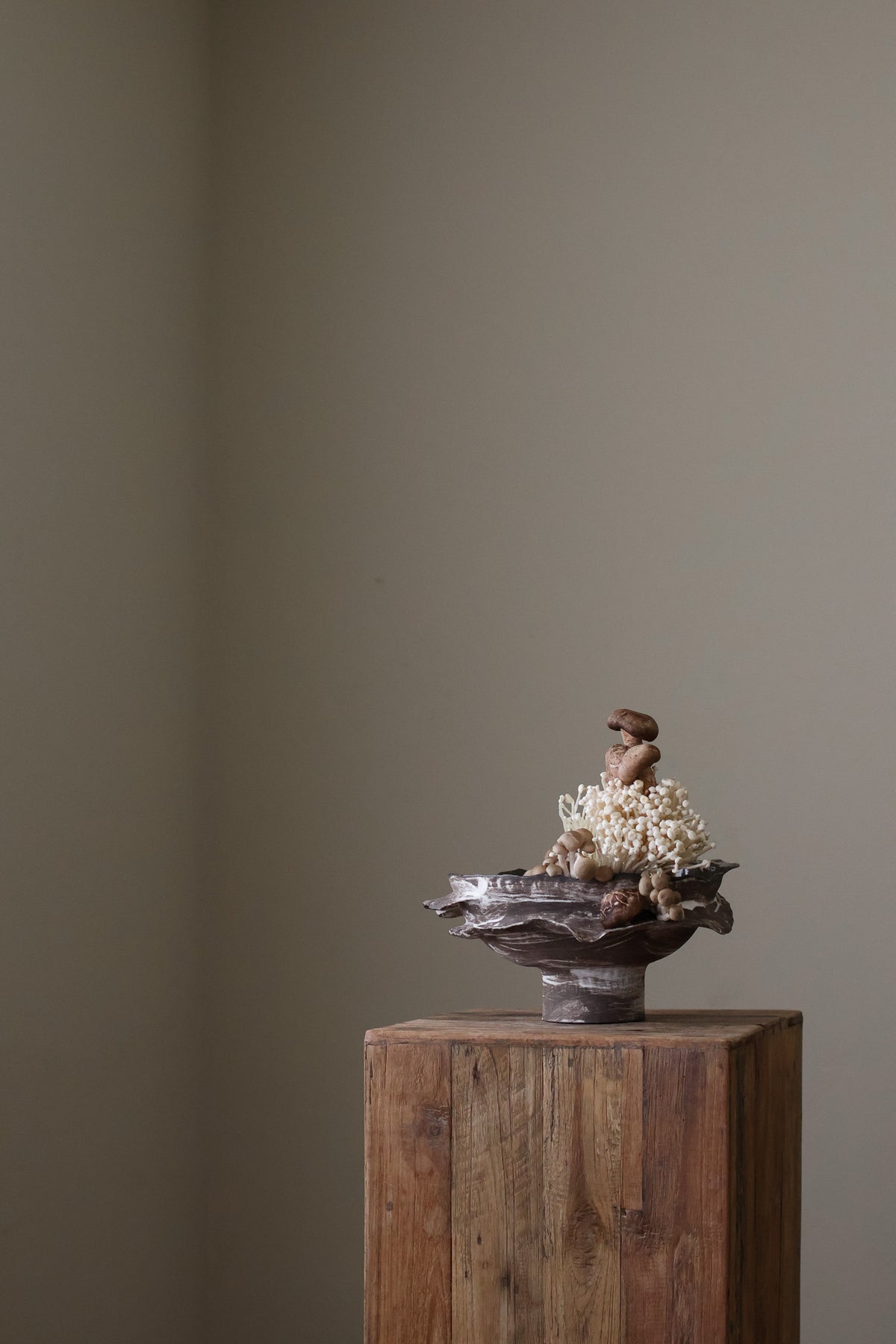 Layered Brown Pedestal Bowl is a Handcrafted ceramic piece with raw, textured dark clay finish and organic wavy rim, featuring sculptural asymmetry