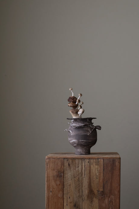 Layered Small Brown Vase is a Handcrafted ceramic Vase with raw, textured dark clay finish and organic wavy rim, featuring sculptural asymmetry