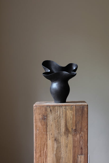 The Luna Sculptural Vessel by Karen Quirion, with sharp angles and a muted ink color, blending brutalist design with delicate, lyrical elements. A perfect statement piece for modern decor.