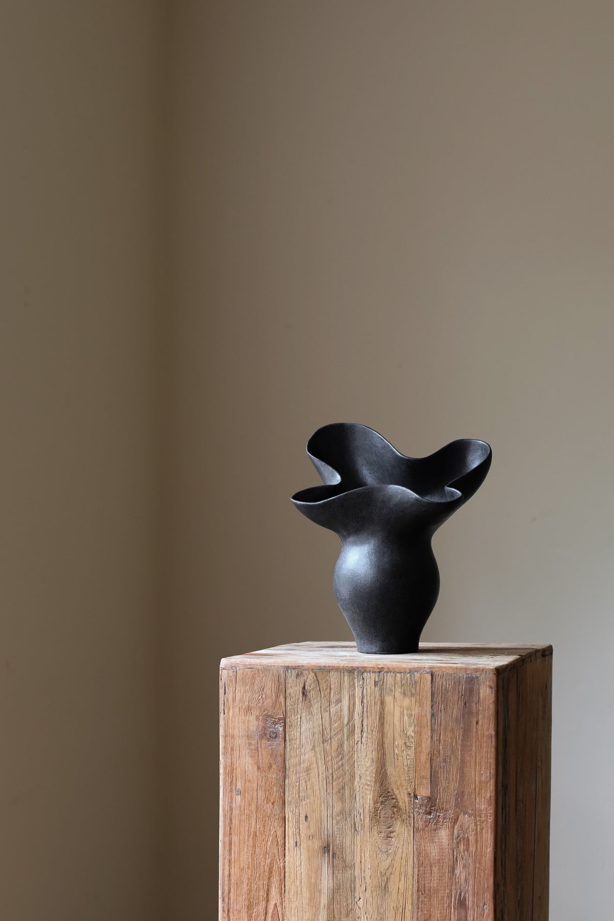 The Luna Sculptural Vessel by Karen Quirion, with sharp angles and a muted ink color, blending brutalist design with delicate, lyrical elements. A perfect statement piece for modern decor.