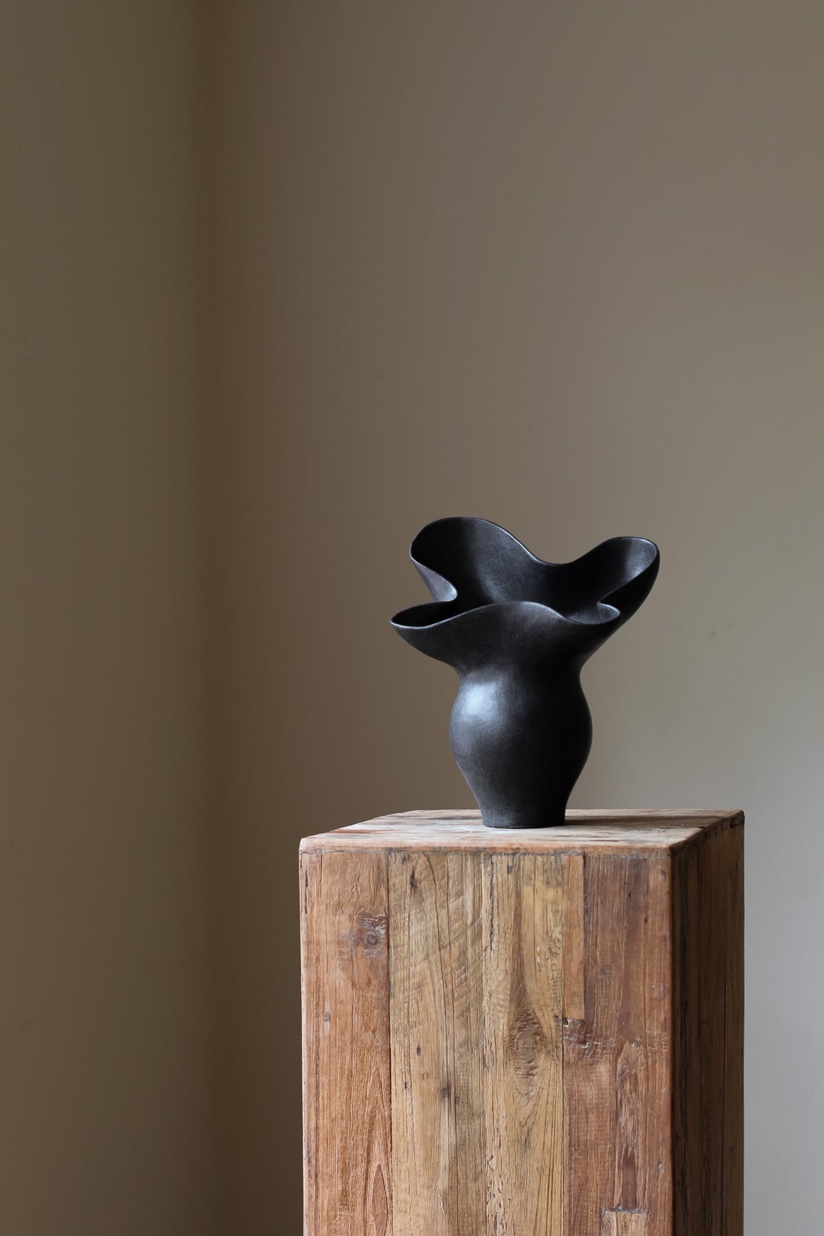 The Luna Sculptural Vessel by Karen Quirion, with sharp angles and a muted ink color, blending brutalist design with delicate, lyrical elements. A perfect statement piece for modern decor.