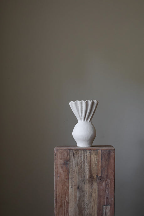 Hand-built gray sculptural vase with a heavily textured, almost sandy surface and a dramatically fluted, ruffled rim