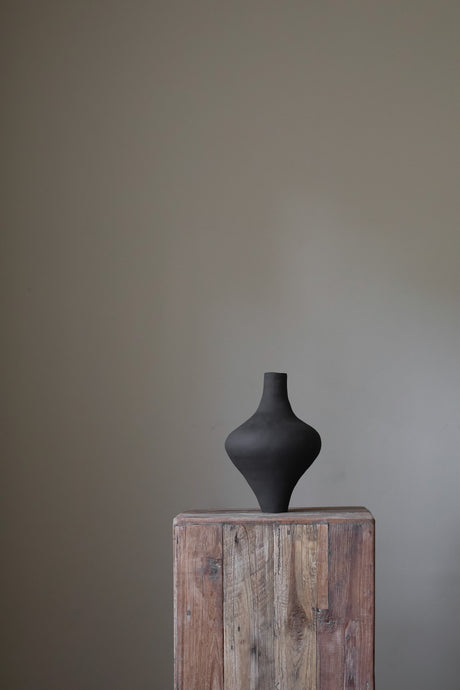 Unique black sculptural vessel, showcasing a modern aesthetic and hand-built texture.