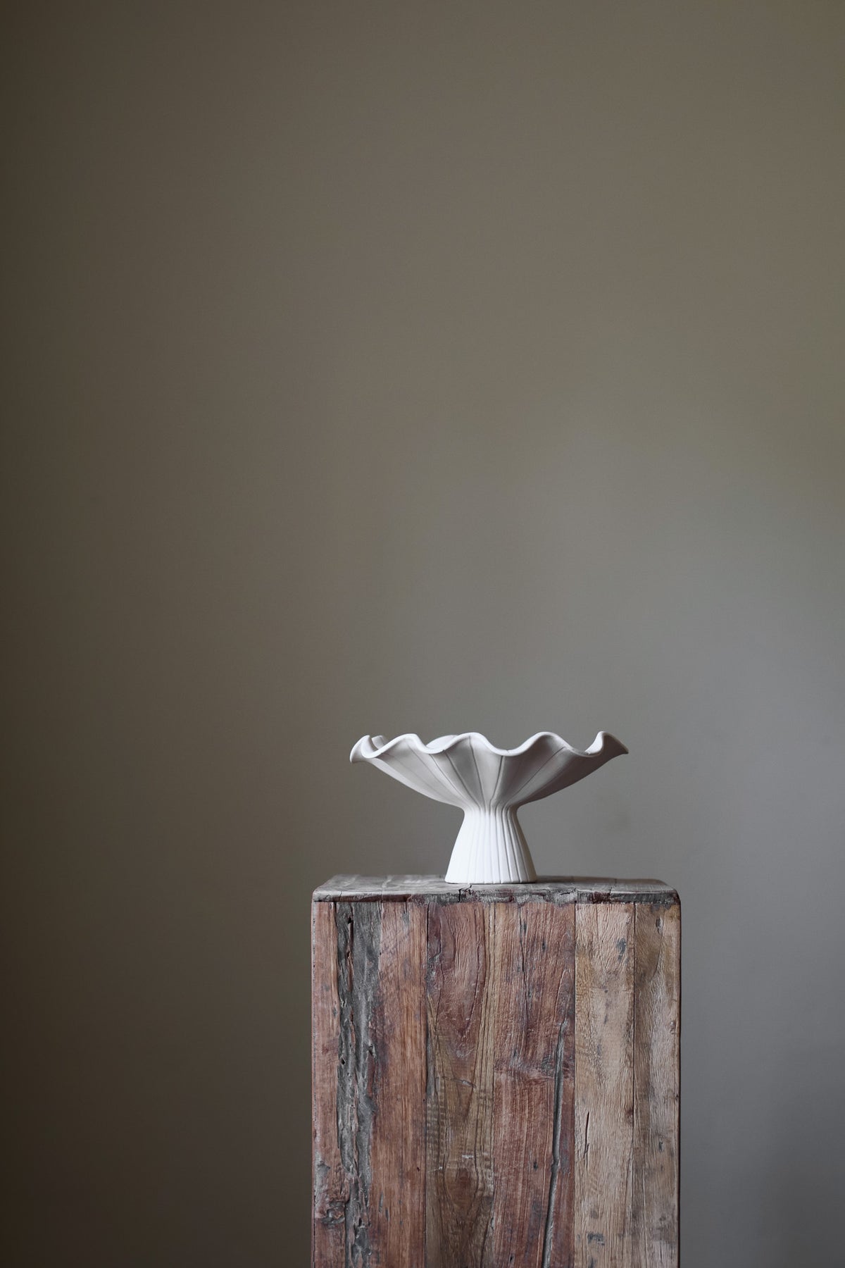 Hand-built white ceramic bowl with a fluted, ribbed base and a dramatically ruffled, undulating rim