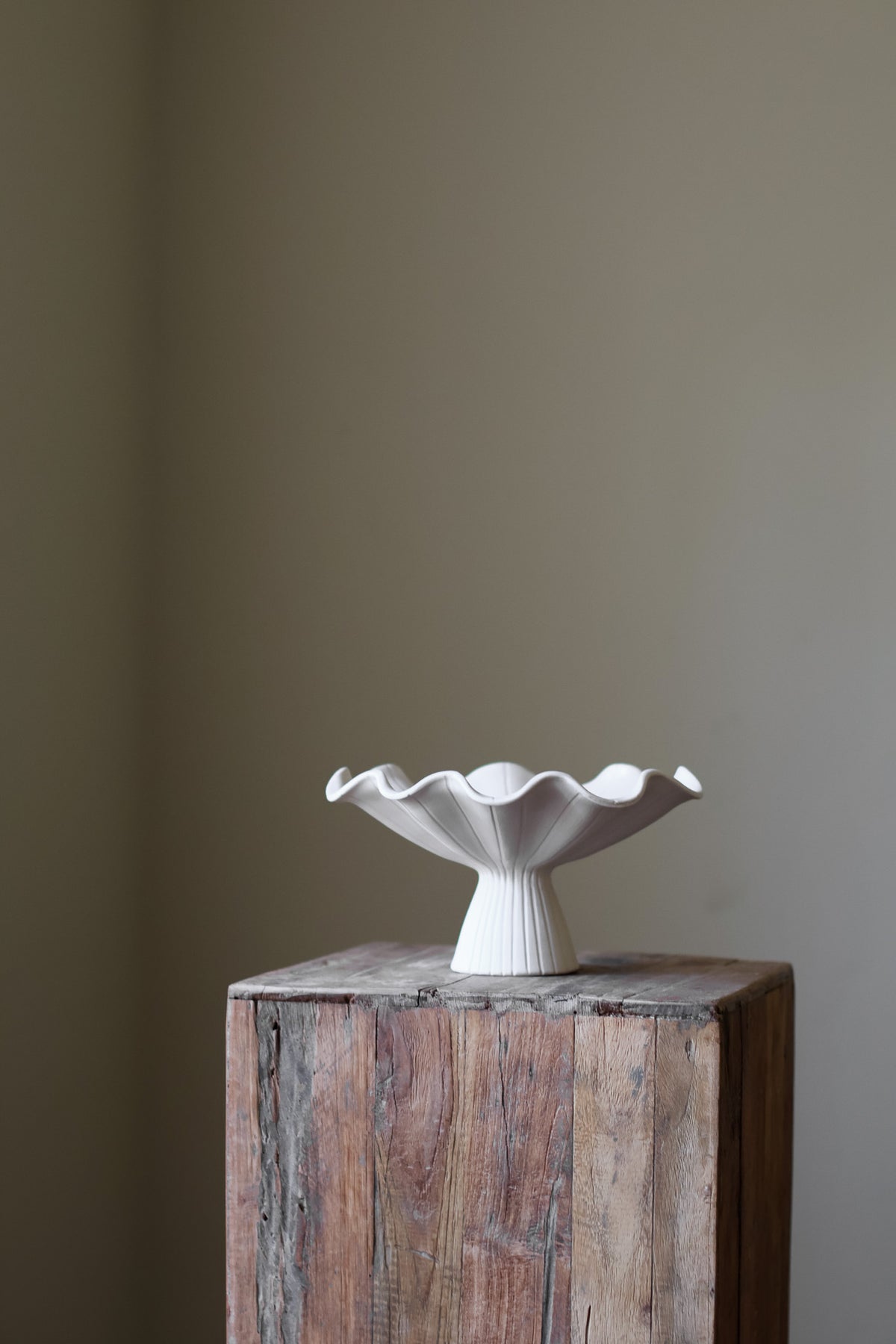 Hand-built white ceramic bowl with a fluted, ribbed base and a dramatically ruffled, undulating rim