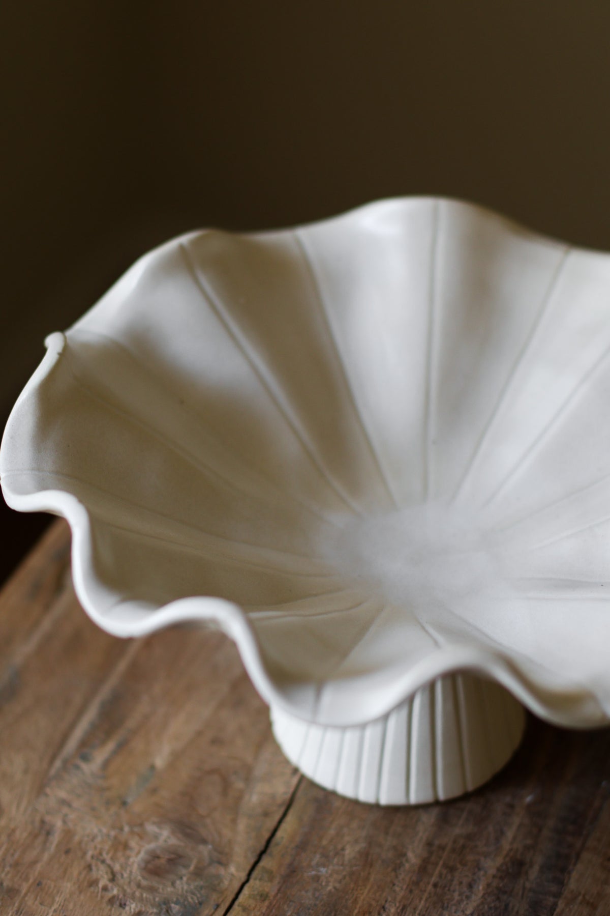 Hand-built white ceramic bowl with a fluted, ribbed base and a dramatically ruffled, undulating rim