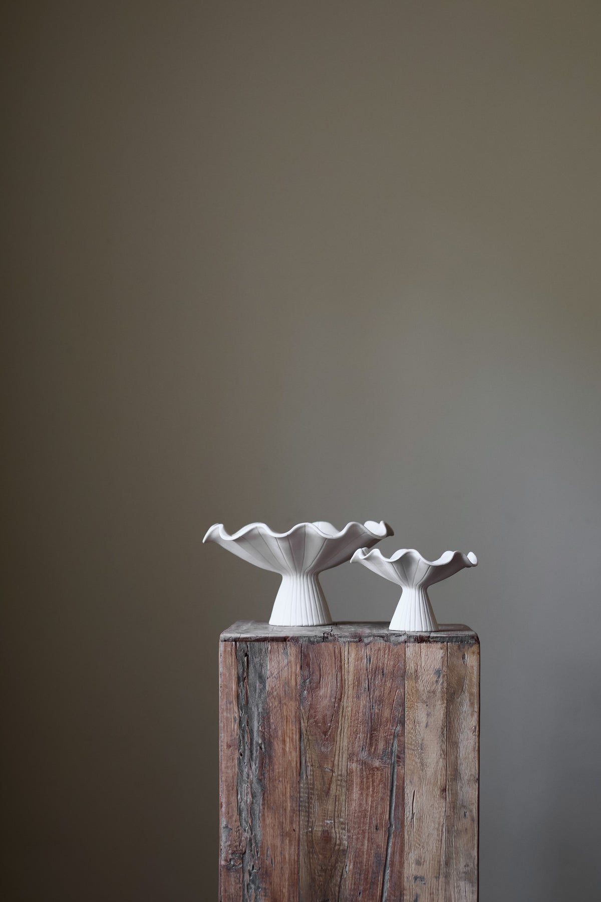 Hand-built white ceramic bowl with a fluted, ribbed base and a dramatically ruffled, undulating rim