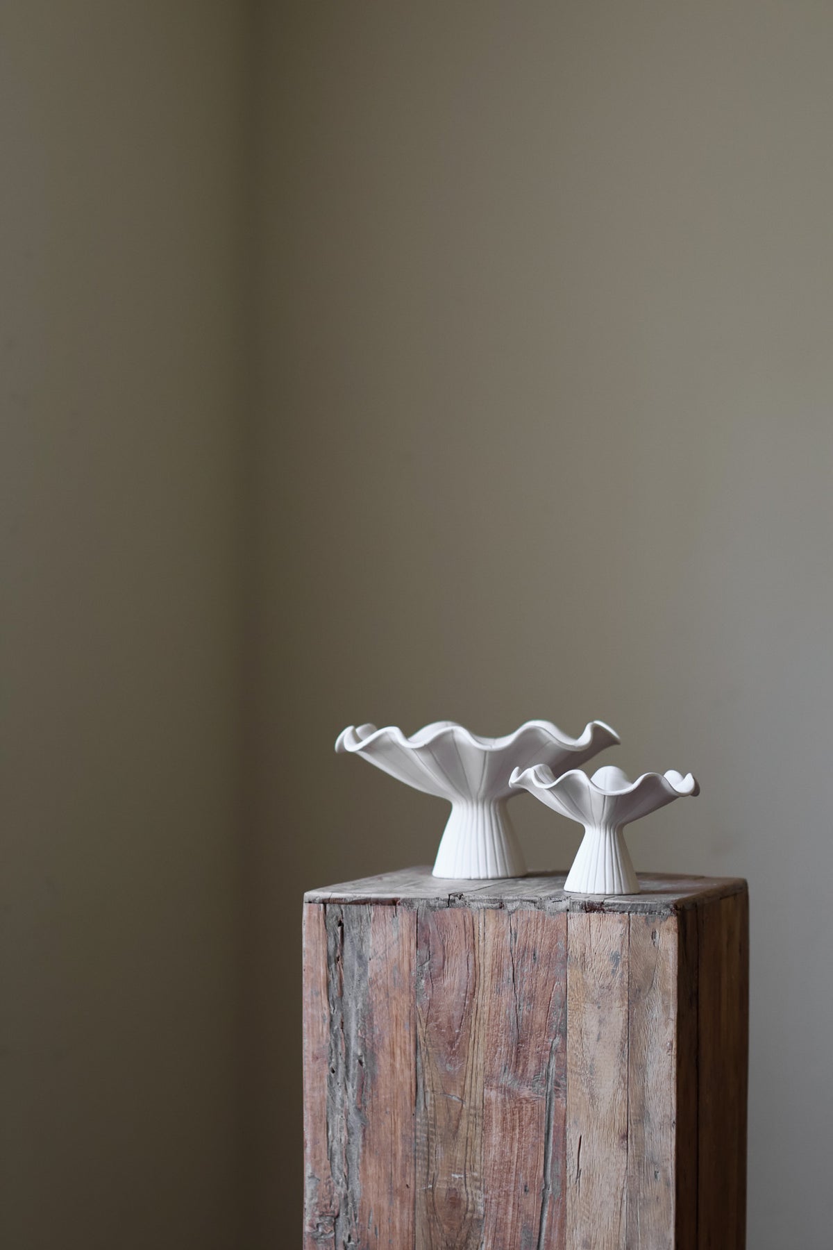 Hand-built white ceramic bowl with a fluted, ribbed base and a dramatically ruffled, undulating rim