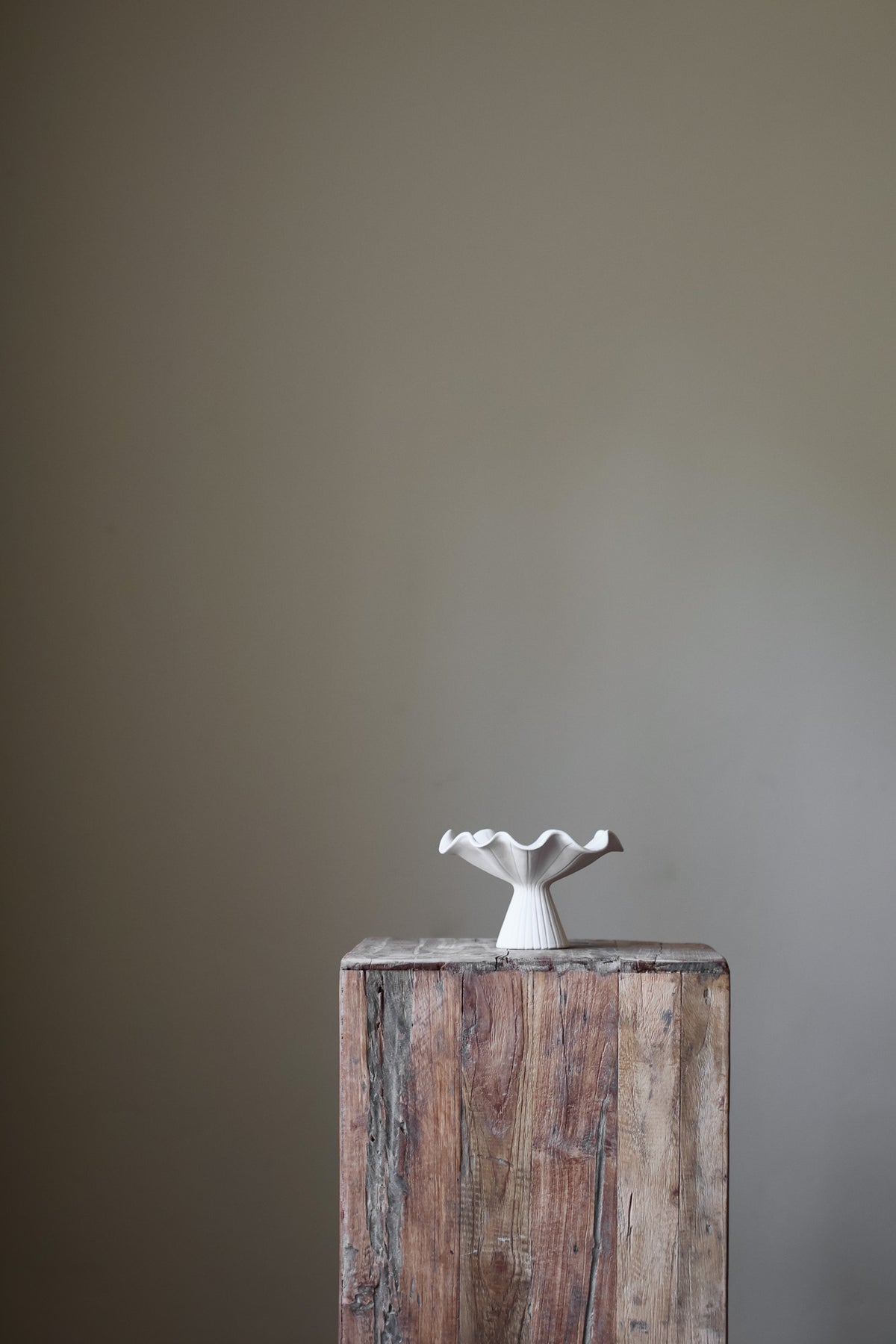 Hand-built white ceramic bowl with a fluted, ribbed base and a dramatically ruffled, undulating rim