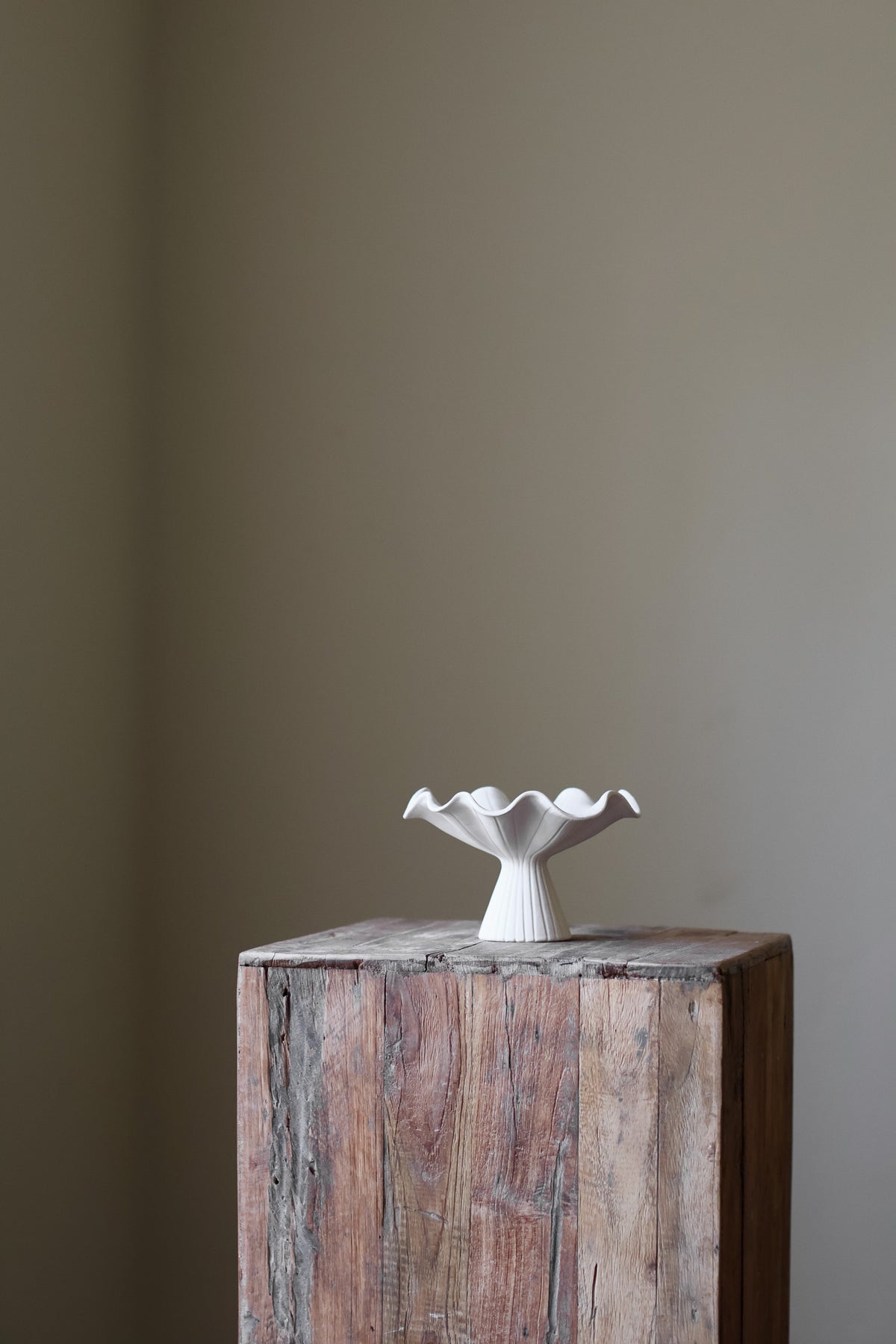 Hand-built white ceramic bowl with a fluted, ribbed base and a dramatically ruffled, undulating rim