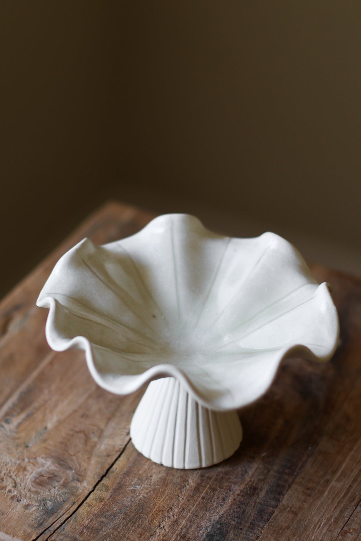Hand-built white ceramic bowl with a fluted, ribbed base and a dramatically ruffled, undulating rim