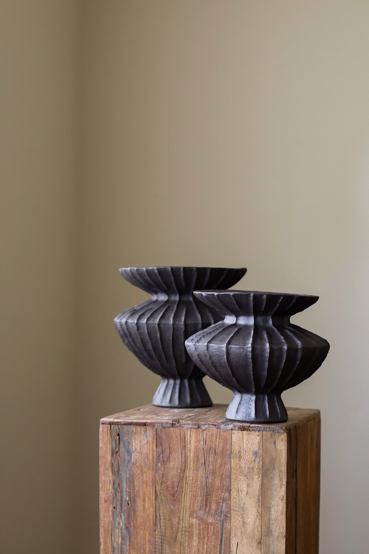 Hand-built dark ceramic vase with a rich, textured ribbed surface and a gently flared rim.