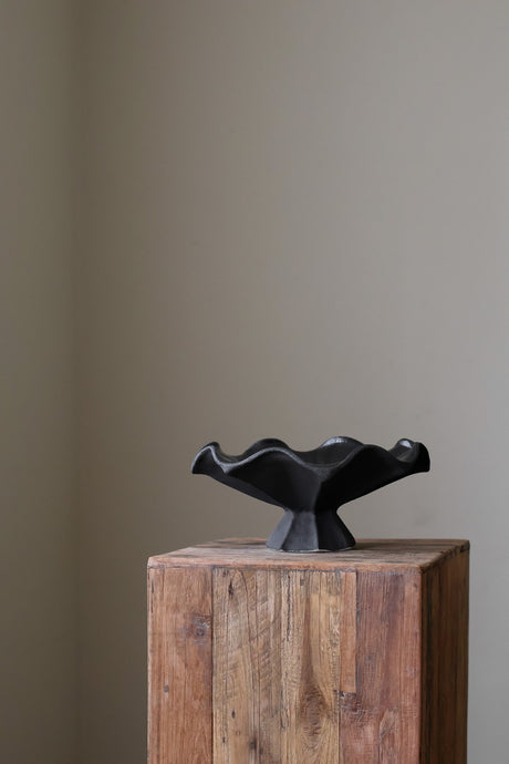 Hand-built dark ceramic bowl with a fluted, faceted pedestal base and a dramatically ruffled, undulating rim.