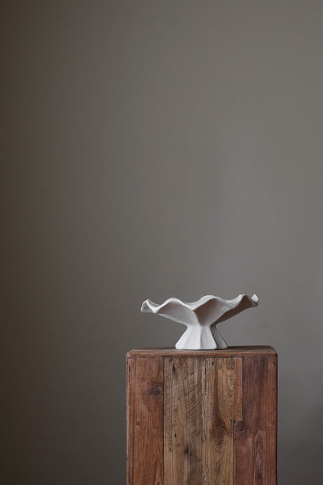 Hand-built white ceramic bowl with a fluted, faceted pedestal base and a dramatically ruffled, undulating rim.