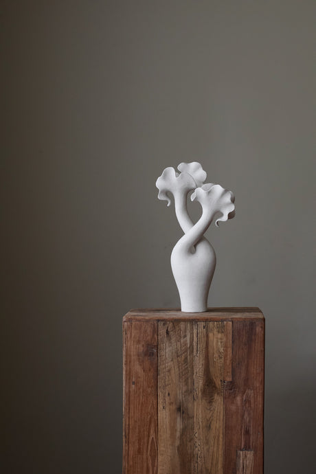 Hand-built sculptural piece with flowing, organic shapes and a textured, matte finish.