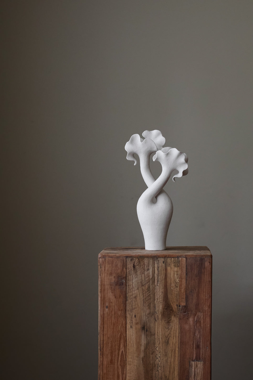 Hand-built sculptural piece with flowing, organic shapes and a textured, matte finish.