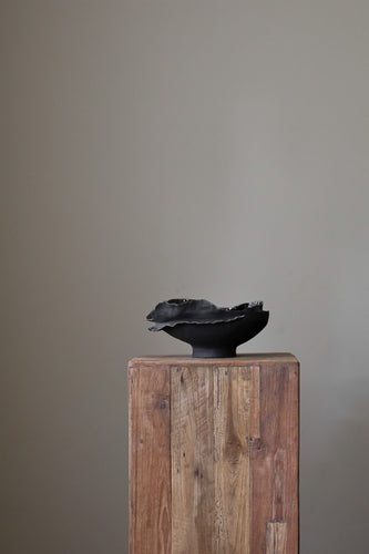 Hand-built dark ceramic bowl with a heavily textured surface, an irregular, sculpted rim, and thin silver lines along the edge. 
