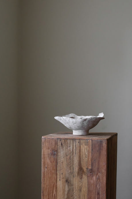 Hand-built dark ceramic bowl with a heavily textured surface, an irregular, sculpted rim, and thin silver lines along the edge. 