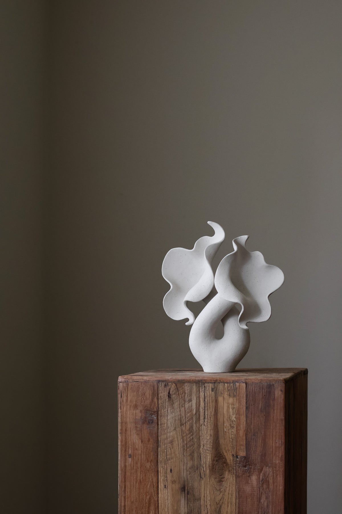 Hand-built white sculptural piece with flowing, organic shapes and a textured, matte finish.