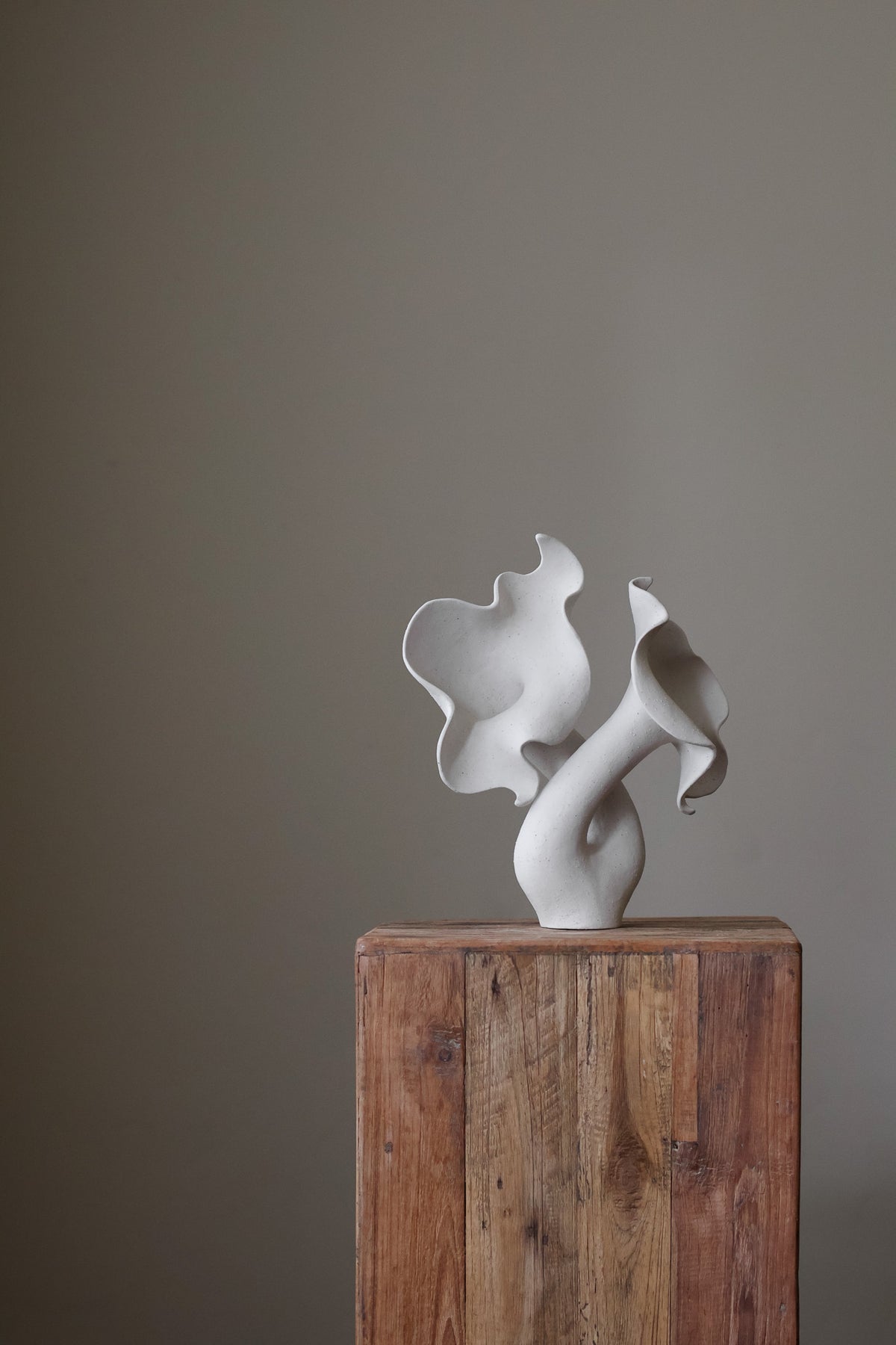 Hand-built white sculptural piece with flowing, organic shapes and a textured, matte finish.