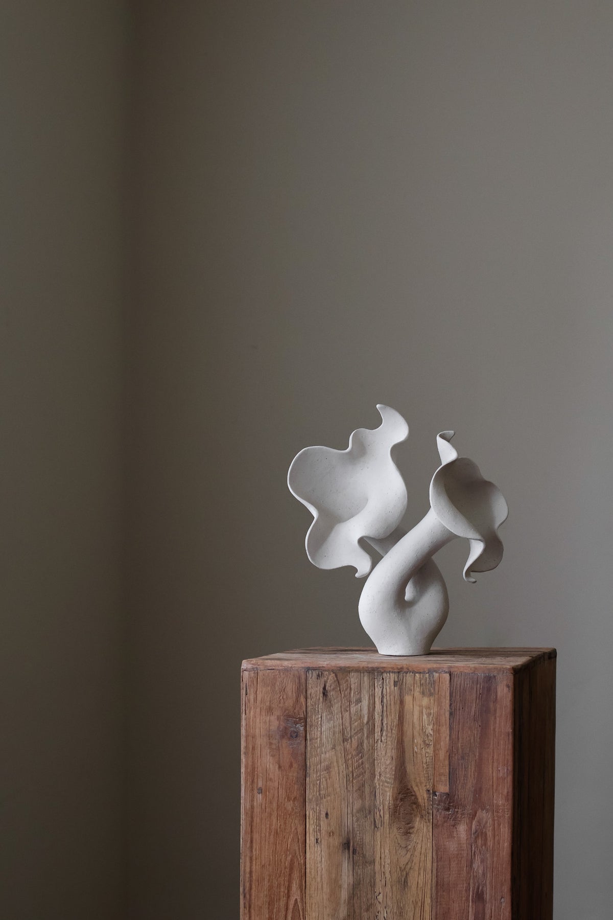 Hand-built white sculptural piece with flowing, organic shapes and a textured, matte finish.
