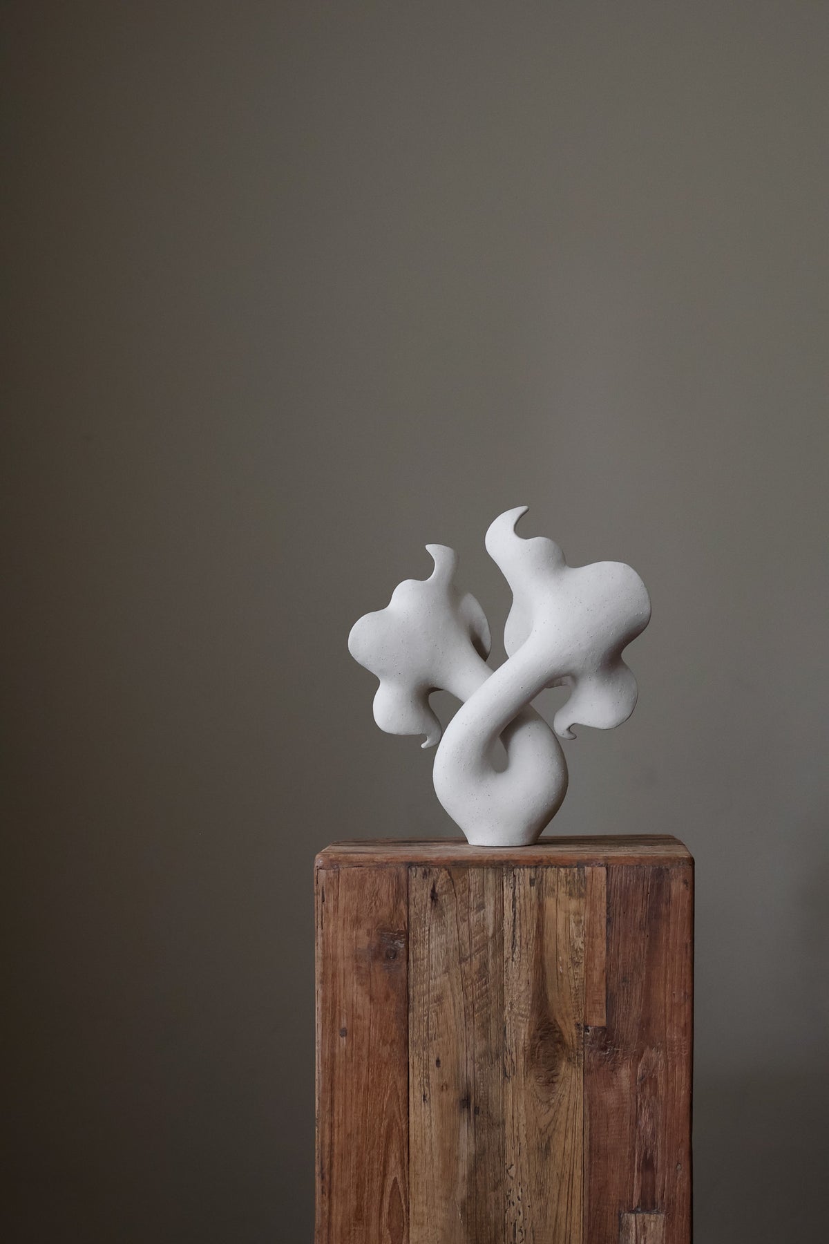 Hand-built white sculptural piece with flowing, organic shapes and a textured, matte finish.