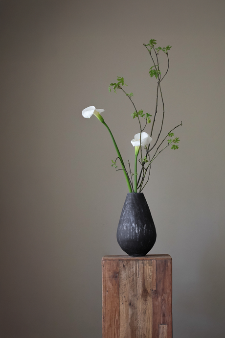 Black ceramic teardrop vase by Giselle Hicks, featuring a heavily textured surface and a distinctive, sculptural form.