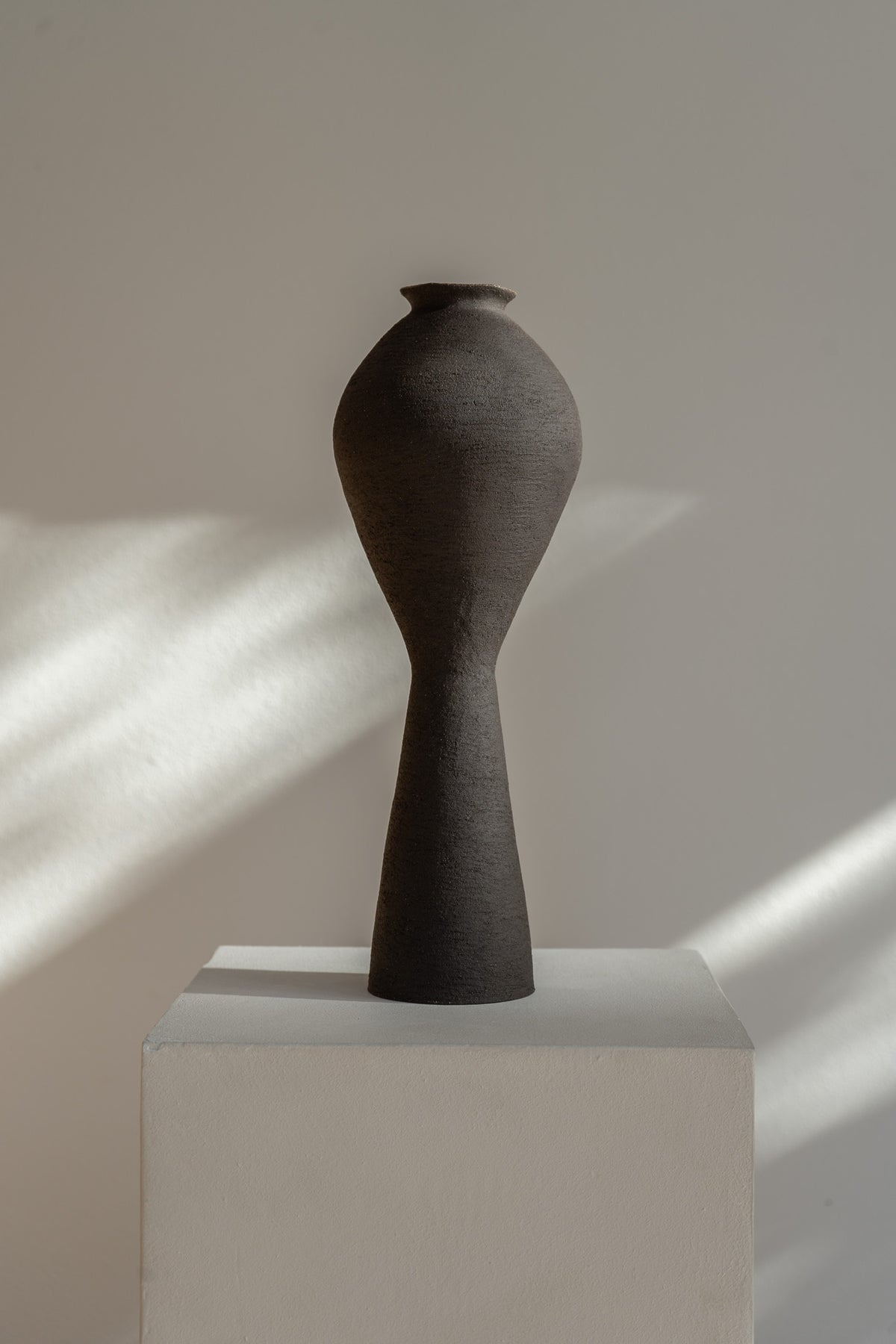 Large Ovular Vase by Ruby Bell Ceramics, hand-built with a raw textured black exterior and clear glazed interior, embodying the grace of the female form. This unique sculptural piece showcases the tactile beauty of clay, perfect for a statement accent or floral display.