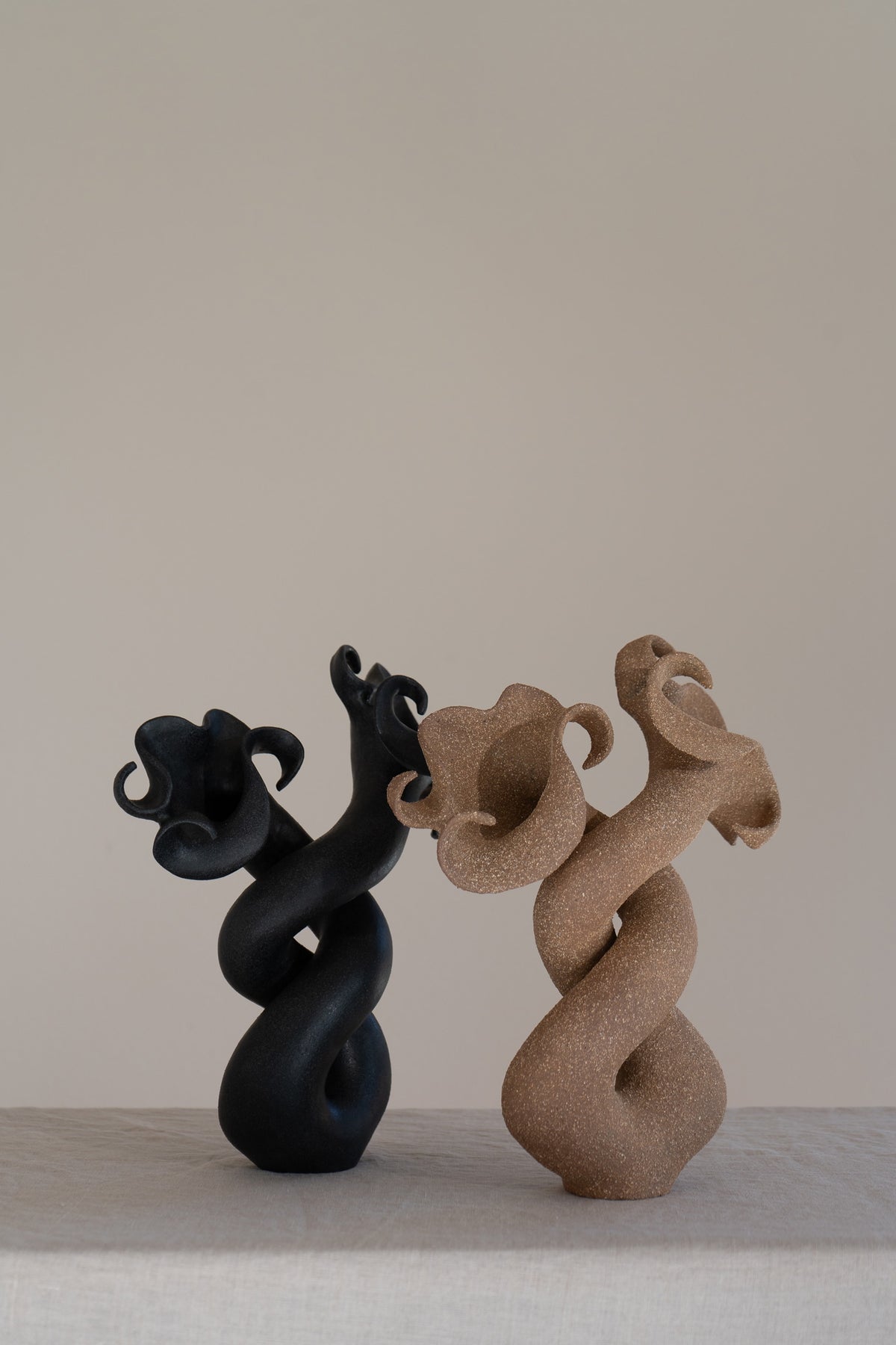 A striking matte brown ceramic vessel with curvaceous and organic shapes, combining soft brutalism with nature-inspired design. 