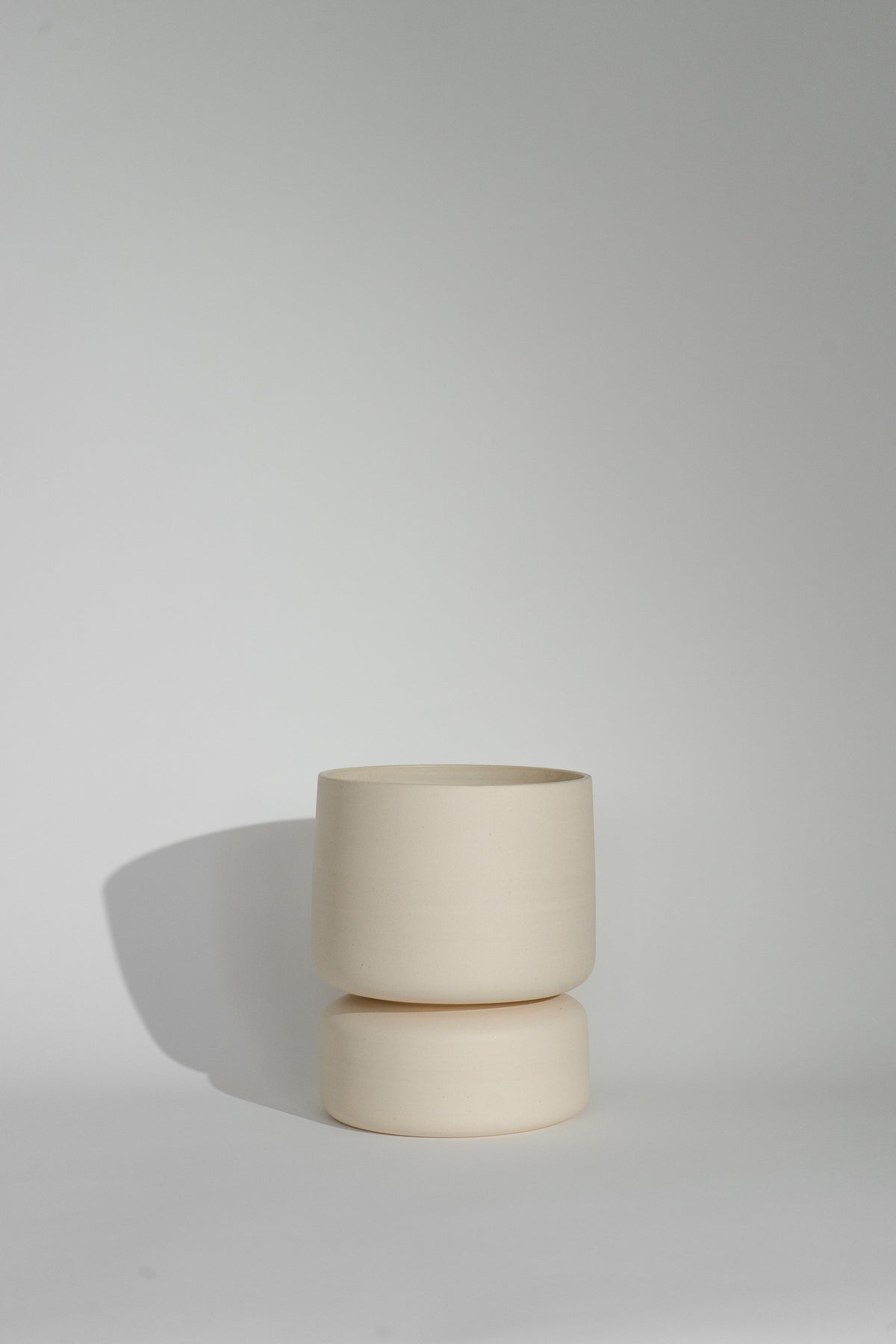 Crafted in cream with a sleek two-piece design, this stylish planter elevates any space. Featuring a removable top for easy water disposal or self-watering, it enhances your home décor while showcasing nature's beauty.