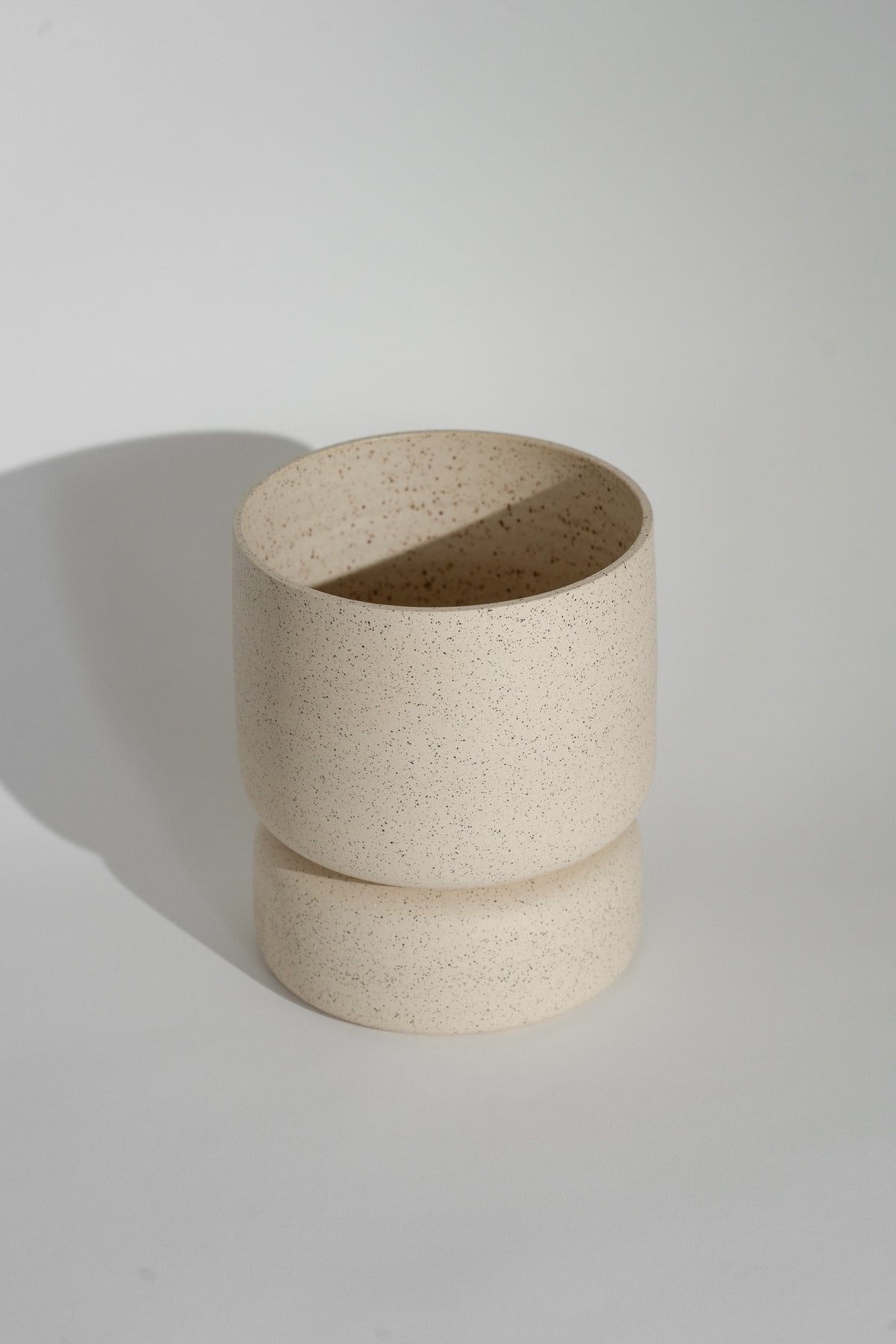 Crafted in cream with a sleek two-piece design, this stylish planter elevates any space. Featuring a removable top for easy water disposal or self-watering, it enhances your home décor while showcasing nature's beauty.