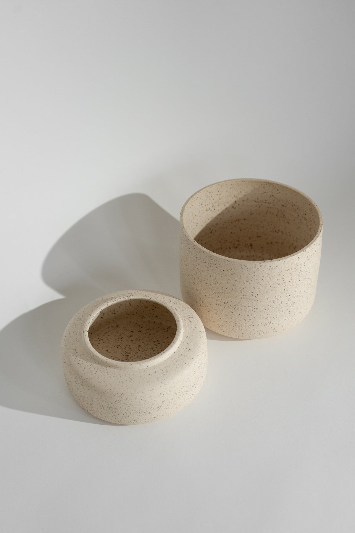 Crafted in cream with a sleek two-piece design, this stylish planter elevates any space. Featuring a removable top for easy water disposal or self-watering, it enhances your home décor while showcasing nature's beauty.