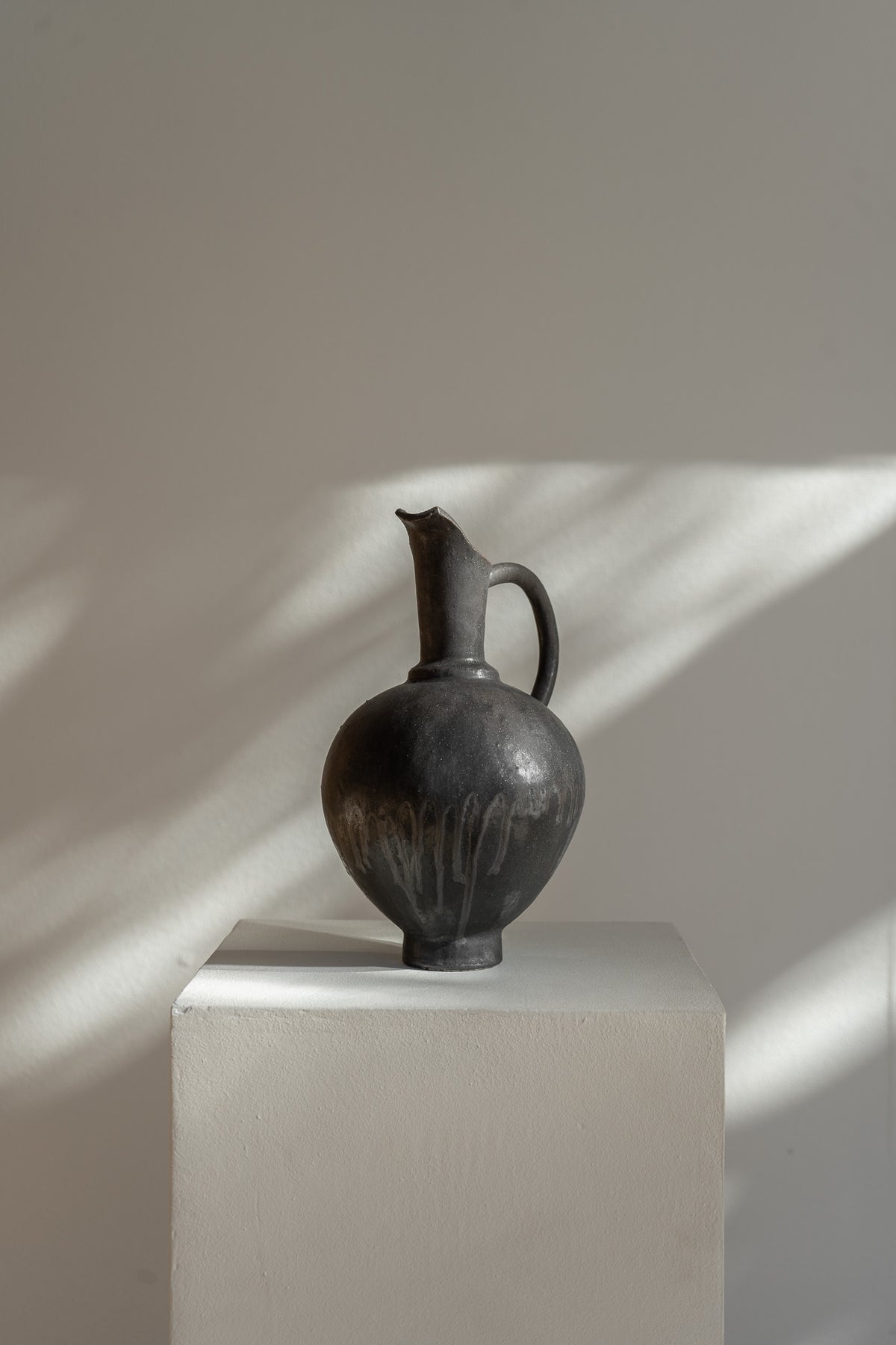 Handmade Oinochoe Pitcher INK by Canoa Lab, featuring a matte black glaze and textured stoneware. Inspired by ancient Mediterranean design, this decorative vase adds timeless elegance to any space.