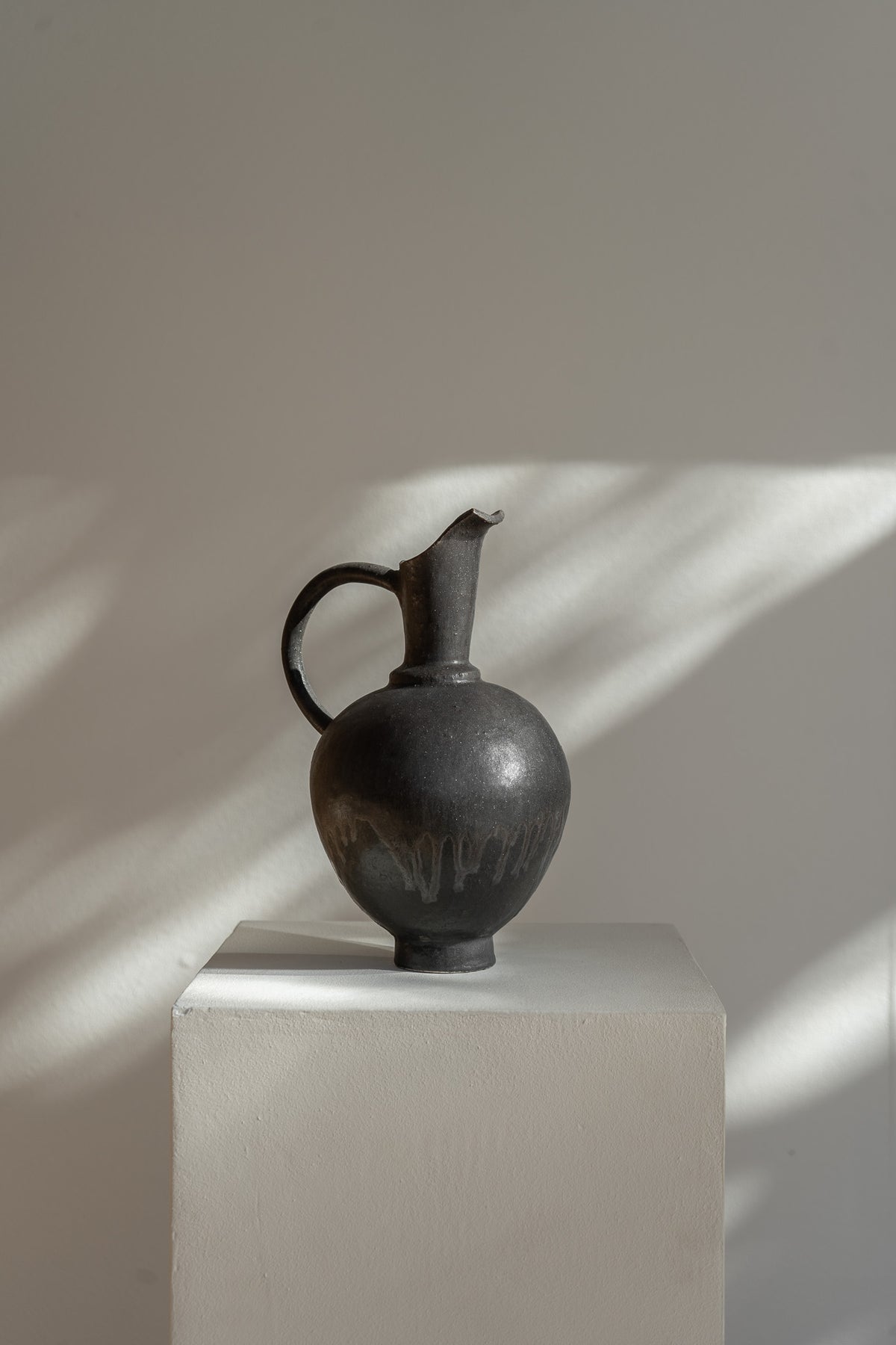Handmade Oinochoe Pitcher INK by Canoa Lab, featuring a matte black glaze and textured stoneware. Inspired by ancient Mediterranean design, this decorative vase adds timeless elegance to any space.